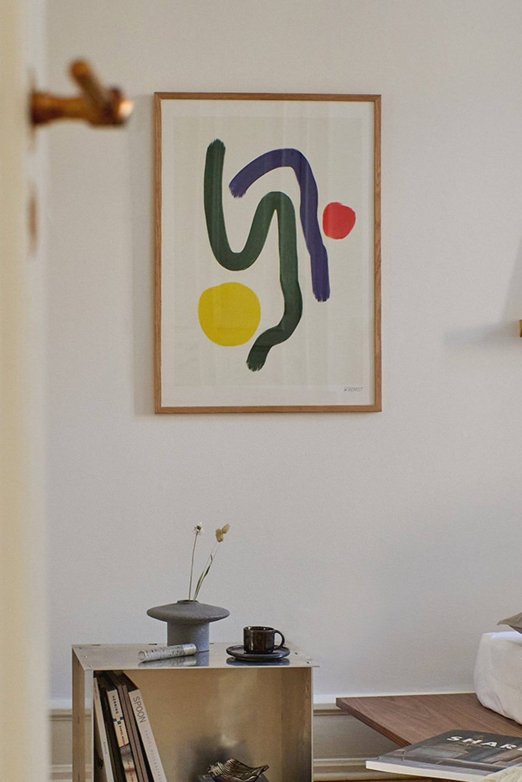 The Poster Club Volare, a contemporary abstract art print featuring bold, organic brushstrokes in dark green and deep purple, accented by vibrant yellow and red circular shapes on an off-white background. This modern wall art is framed in a light natural oak frame, ideal for minimalist living rooms or Scandinavian-inspired bedrooms.