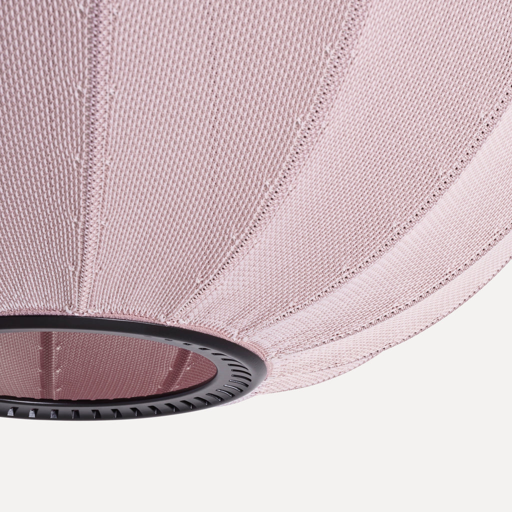 Made by Hand Knit-Wit Ø45 Oval Pendant Lamp, a dusty rose knitted fabric pendant light with a finely textured, ribbed surface and a matte black metal ring accent. This modern Scandinavian oval lamp provides soft ambient lighting for contemporary living rooms, minimalist bedrooms, or stylish nursery decor.