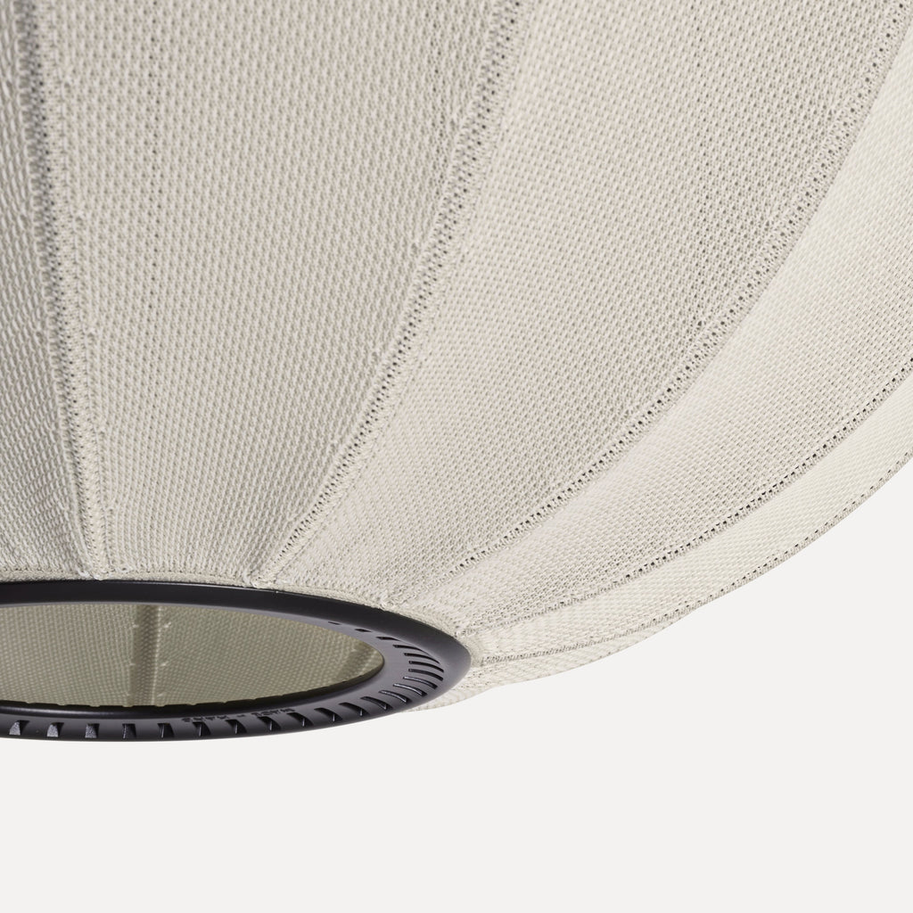Made by Hand Knit-Wit Ø45 Oval Pendant Lamp, a contemporary ceiling light featuring a textured light beige knitted fabric shade with distinct vertical ribbed detailing and a subtle, soft glow, supported by a sleek matte black.