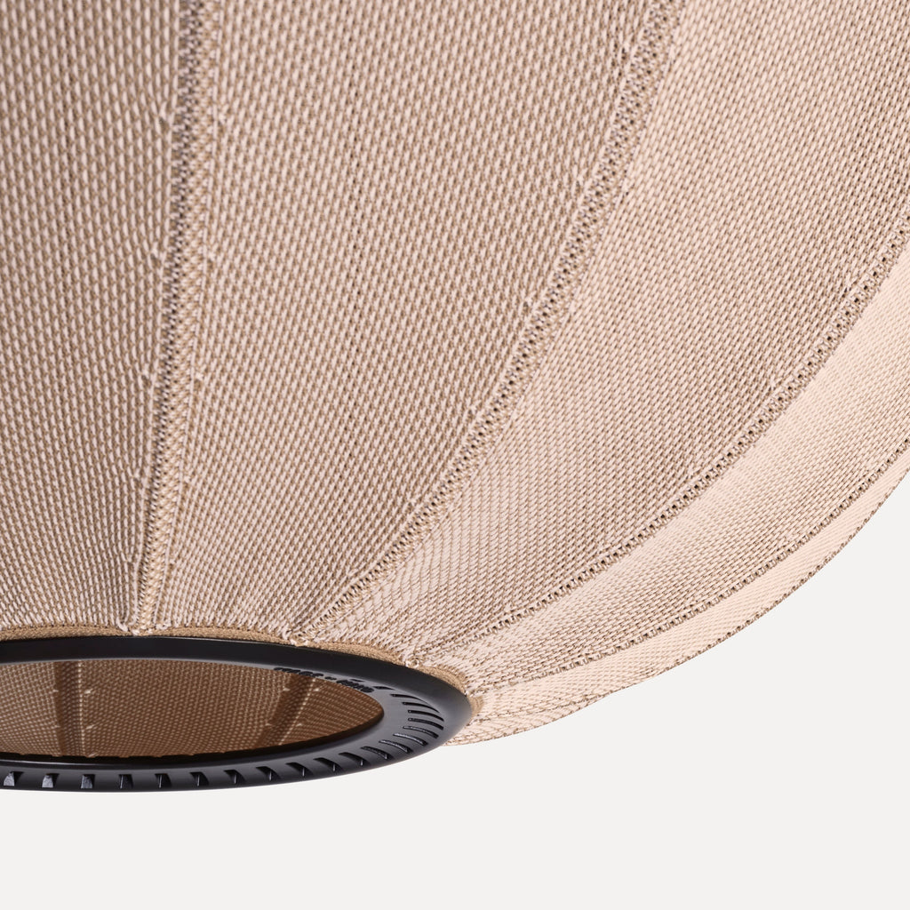 Made by Hand Knit-Wit Ø45 Oval Pendant Lamp, a contemporary Scandinavian pendant lamp featuring a unique hand-knitted textile shade in a warm beige hue. Its soft, ribbed texture and rounded oval silhouette create a cozy, organic modern aesthetic, complemented by a subtle dark metal accent at the base. Ideal for adding ambient lighting to living rooms, dining areas, or bedrooms in minimalist and Nordic-inspired homes.