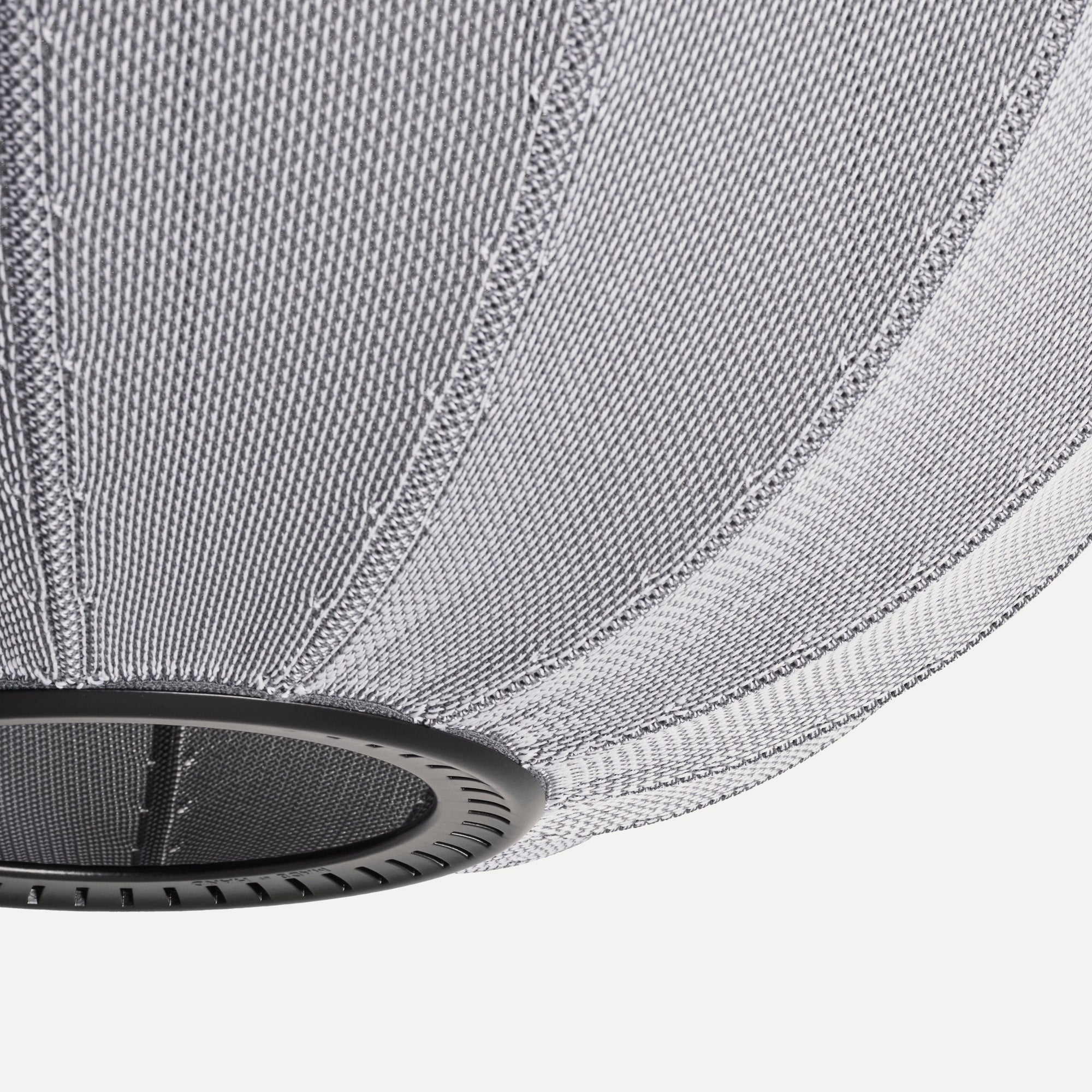 Made by Hand Knit-Wit Ø45 Oval Pendant Lamp, a modern minimalist pendant lamp featuring a unique knitted textile shade in a marled light grey and white weave, creating a soft, warm glow. Its distinctive oval, globe-like silhouette is supported by a sleek matte black metal frame.