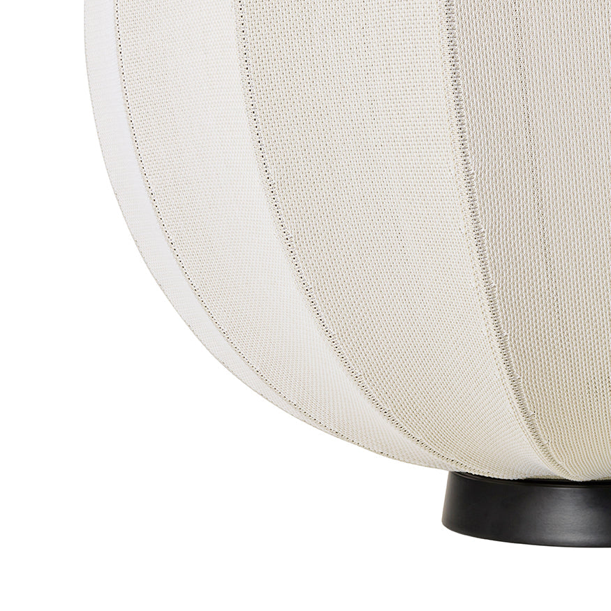 Made by Hand Knit-Wit Ø60 Floor Lamp, a modern minimalist floor lamp featuring a spherical hand-knitted cream textile shade with a distinct ribbed texture and fine vertical lines, elegantly balanced on a sleek matte black metal base. This organic modern lighting piece is perfect for creating warm ambient light in Scandinavian living rooms, cozy bedrooms, or contemporary reading nooks.