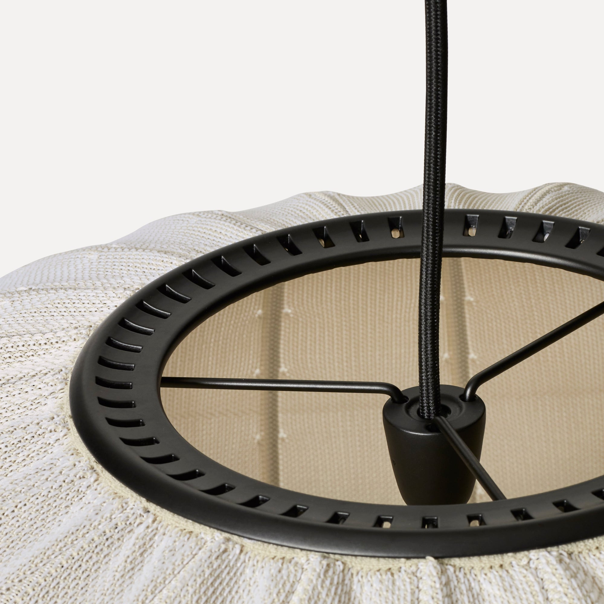 Made by Hand Knit-Wit Ø45 Oval Pendant Lamp, a contemporary ceiling light featuring a textured cream knitted fabric shade with a distinctive ribbed pattern and an underlying beige layer, supported by a sleek matte black metal frame and braided textile cable. This organic modern pendant lamp provides cozy ambient lighting, perfect for Scandinavian living rooms, minimalist bedrooms, or stylish dining areas.