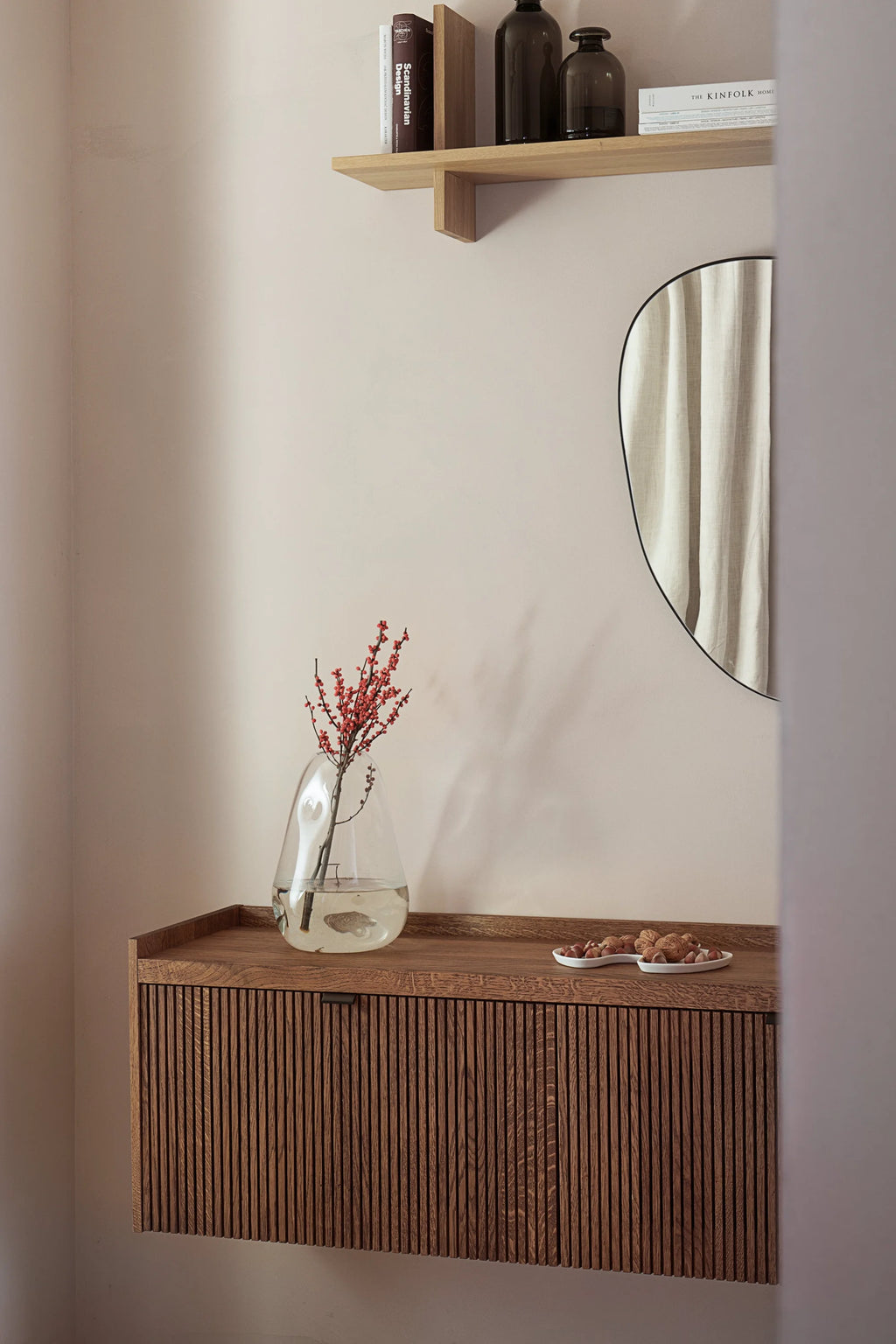 TAMO Meda 2 TV Unit, a luxurious dark brown ribbed oak floating cabinet with a top shelf, styled with a clear vase and nuts in a white dish. Perfect for modern living room storage.