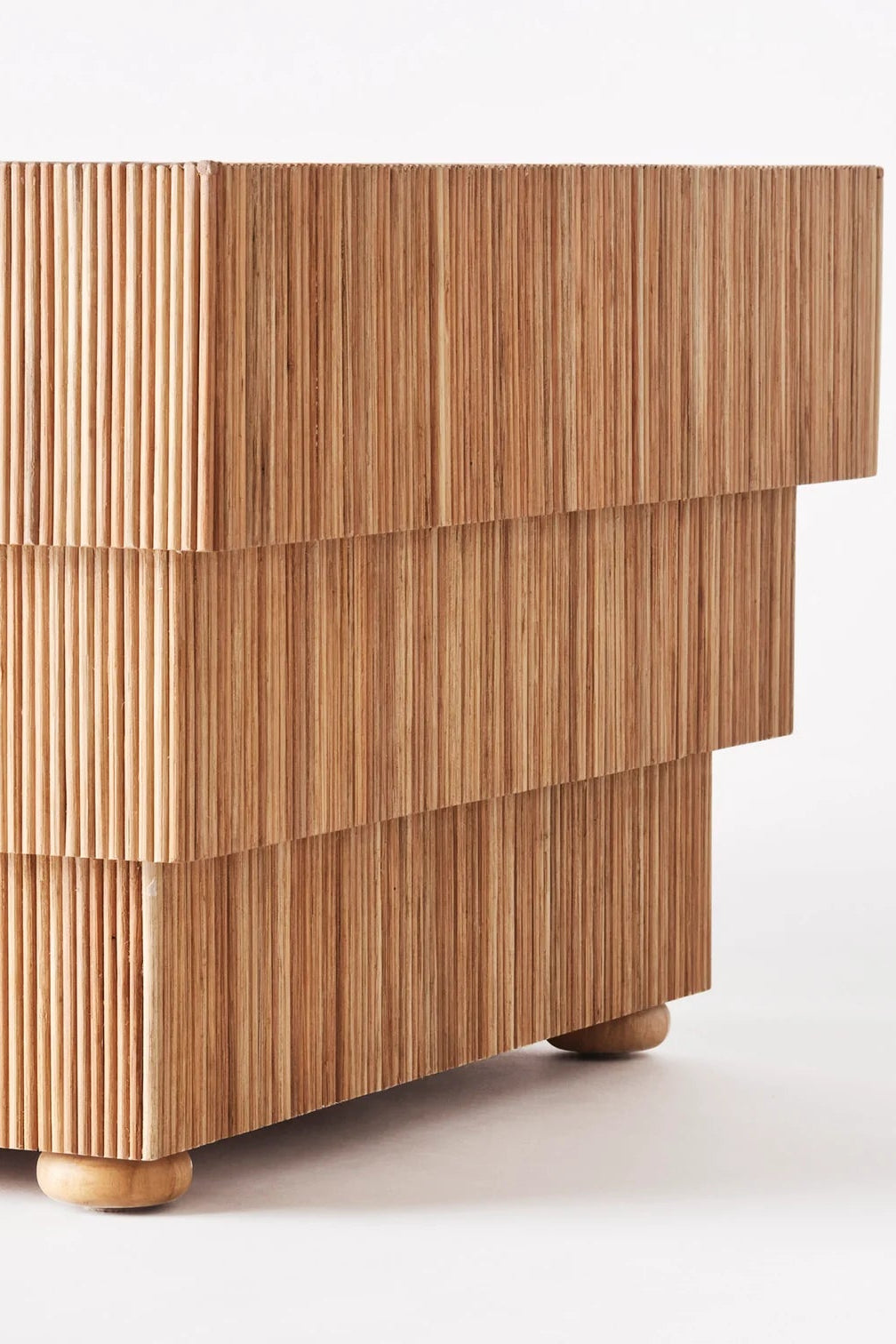 Wooden side table with a striped pattern on a white background