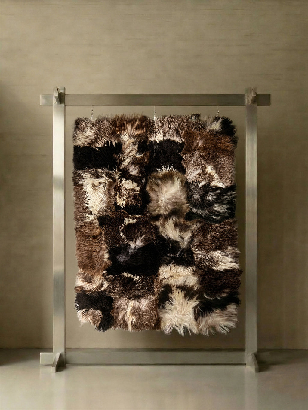 TCL Studios Curly Sheepskin Patchwork Rug, a luxurious natural sheepskin rug composed of a multi-tone patchwork of curly, shaggy textures in rich dark brown, black, and creamy white hues.
