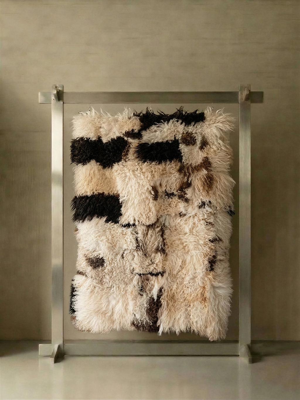 TCL Studios Curly Sheepskin Patchwork Rug, a luxurious shaggy area rug crafted from natural curly sheepskin in a striking patchwork design of cream, black, and warm brown tones.