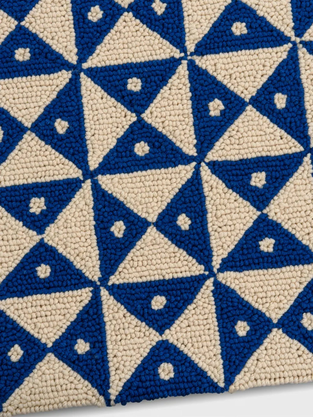 alp_ Mosaic Signature Rug, a vibrant geometric hand-tufted wool rug featuring an intricate mosaic pattern of alternating royal blue and cream triangles. The looped pile texture creates a tactile, plush surface with small cream floral or star-like accents within each blue triangle, adding depth and detail. This contemporary blue and cream area rug is perfect for adding a playful yet sophisticated touch to modern living rooms, eclectic bedrooms, or cozy nurseries.