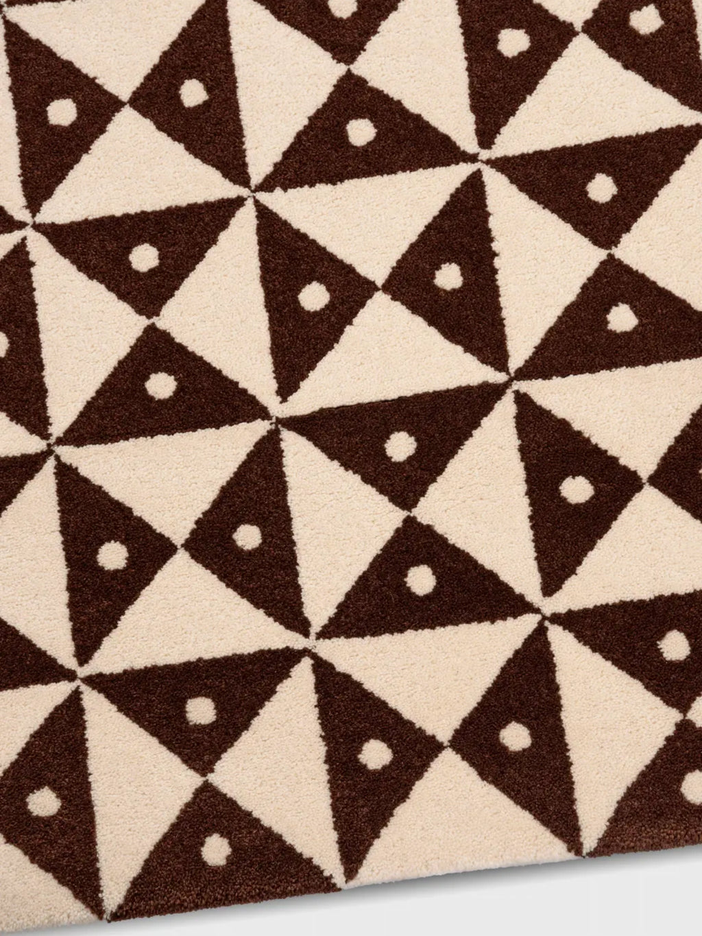 alp_ Mosaic Rug, a plush tufted area rug featuring a bold geometric pattern of alternating cream and chocolate brown triangles, each brown triangle accented with a small cream dot.