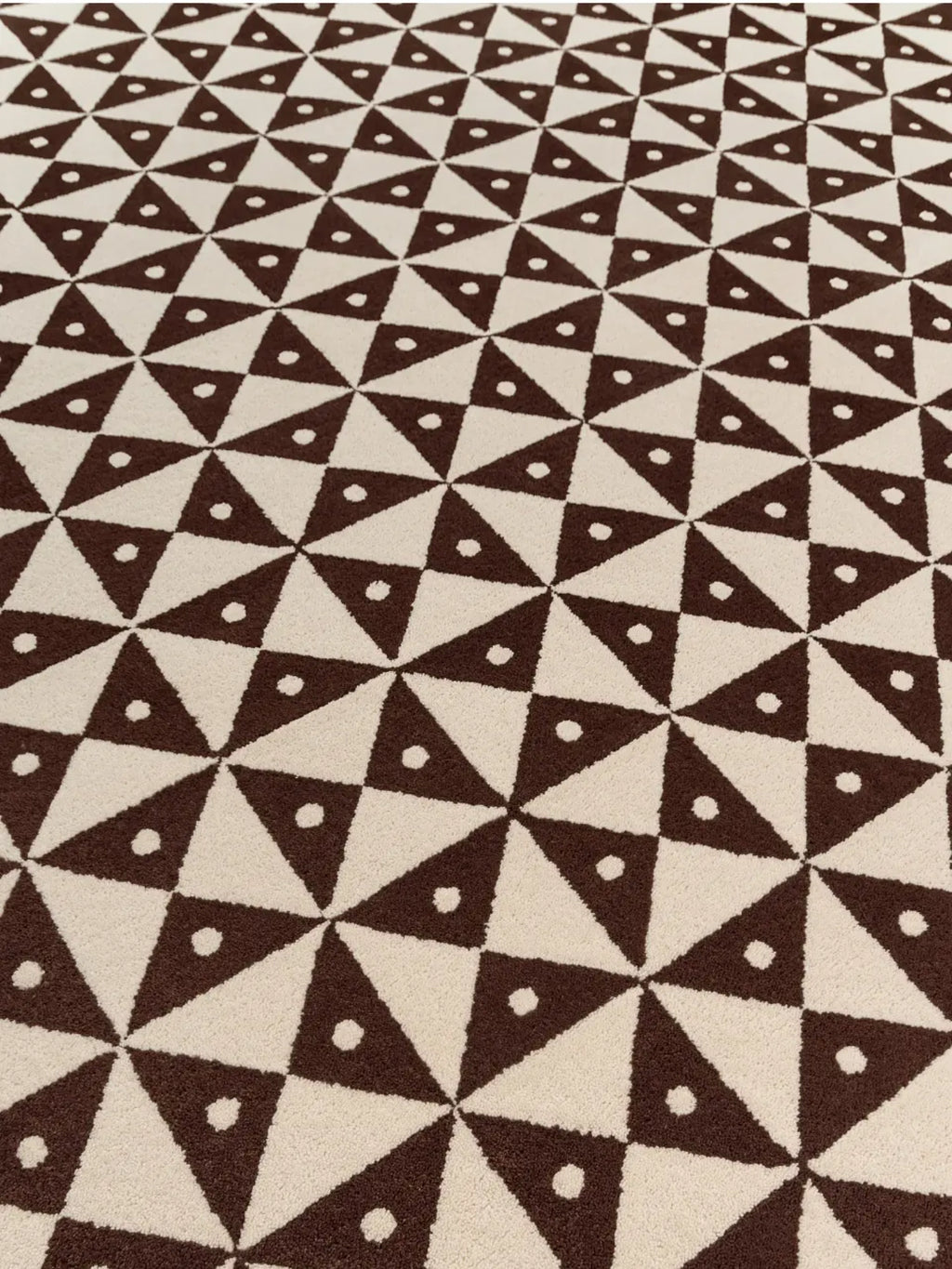 alp_ Mosaic Rug, a contemporary geometric area rug featuring a striking pattern of dark brown triangles and cream-colored opposing triangles, accented with small white circles. This soft pile rug offers a plush texture and graphic appeal, creating a dynamic mosaic effect perfect for modern living rooms, playful bedrooms, or stylish home offices.
