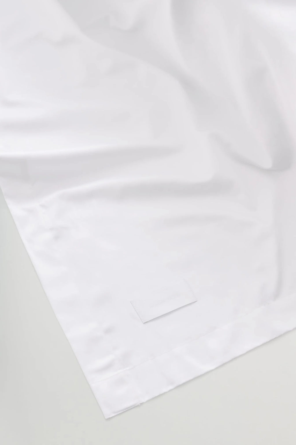Magniberg Mother Sateen Flat Sheet, a crisp white sateen flat sheet with a smooth, lustrous finish and soft, flowing drape. Crafted from premium sateen fabric, it offers a luxurious feel and elegant sheen. Perfect for creating a serene, minimalist bedroom aesthetic or a contemporary luxury bedding experience.