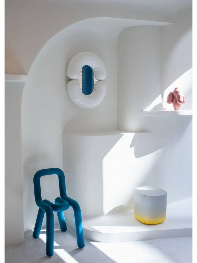 Moustache Bold Chair, a striking contemporary accent chair featuring a continuous, oversized tubular metal frame entirely upholstered in a vibrant petrol blue textile with a soft, matte finish. Its distinctive, rounded, and sculptural silhouette forms both the seat and backrest, creating a playful yet bold design statement. Ideal as a modern dining chair, a unique living room accent, or a statement piece in creative office spaces.