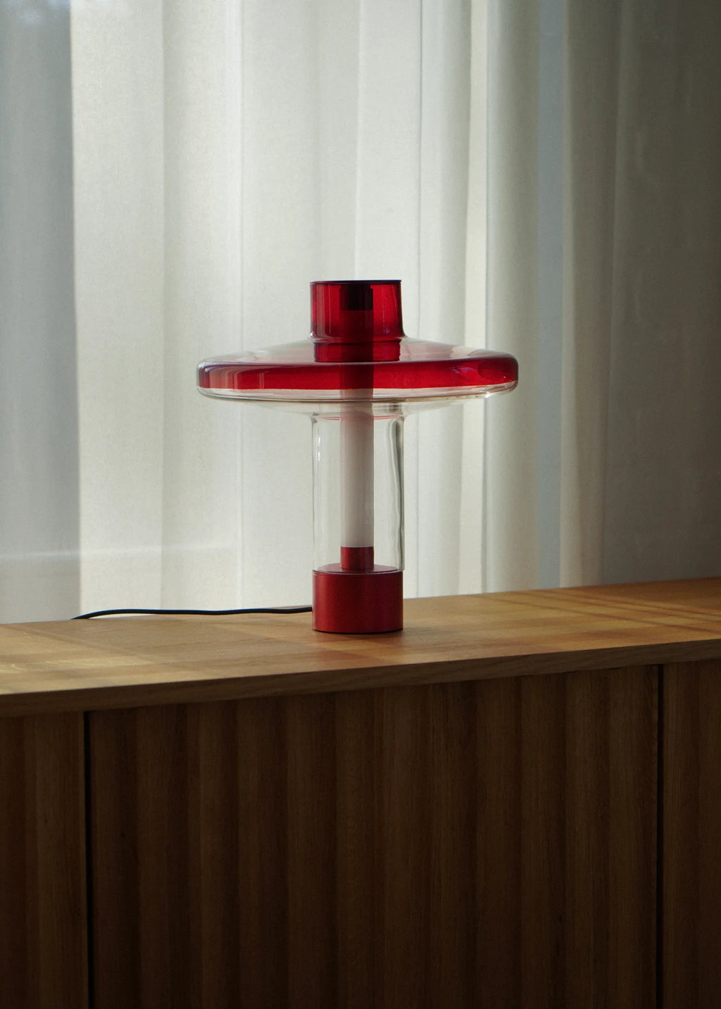 TAMO Nevo Table Lamp, a striking modern minimalist table lamp crafted from vibrant red blown glass and matte red metal, featuring a stacked geometric design.