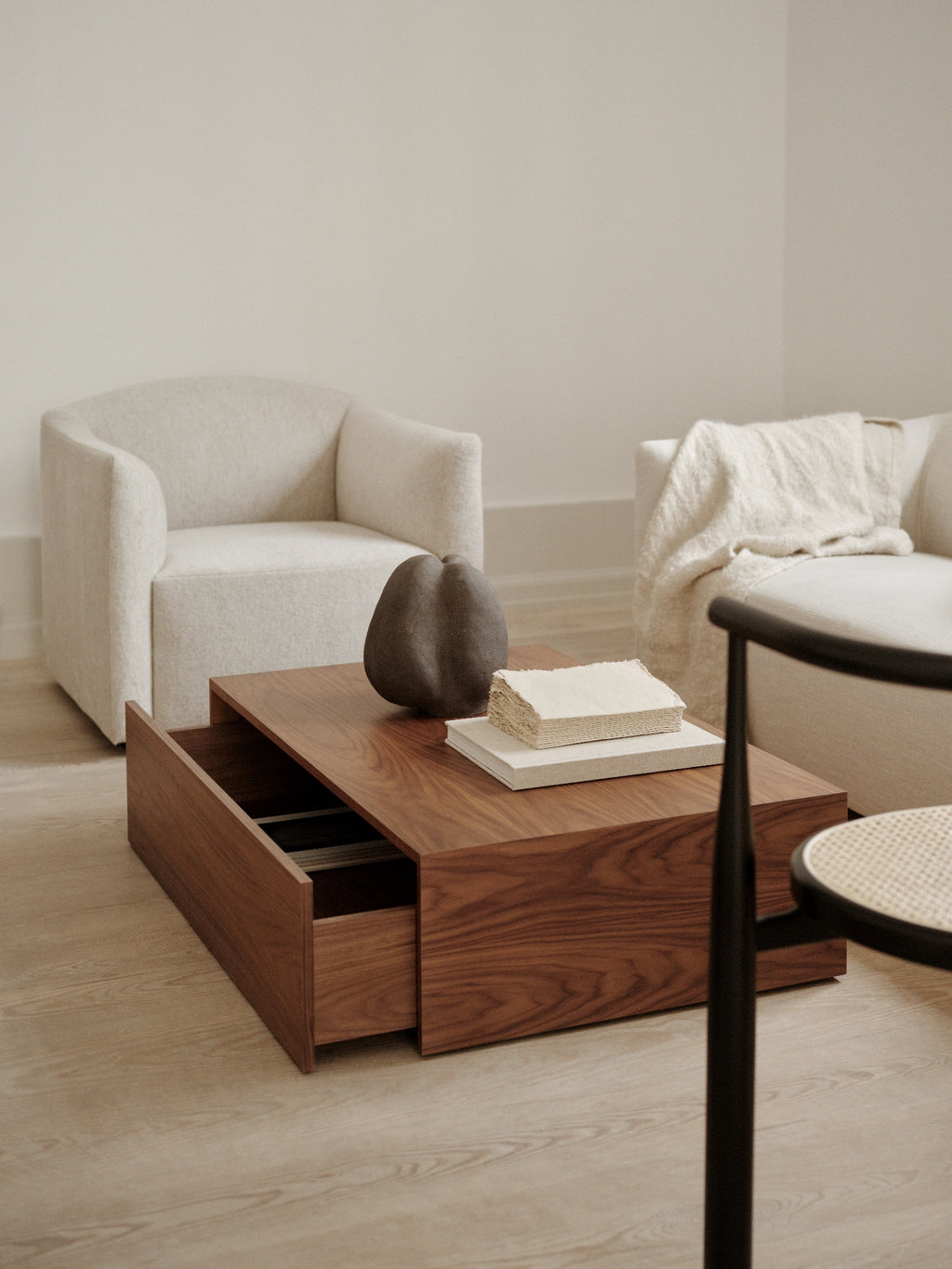 New Works Mass Coffee Table w. Drawer, a rectangular modern minimalist coffee table crafted from rich dark solid walnut wood with a smooth finish and visible grain. This contemporary living room centerpiece features an integrated hidden storage drawer, perfect for keeping spaces tidy and organized. Ideal as a stylish Scandinavian coffee table for design-conscious homes and modern interiors.