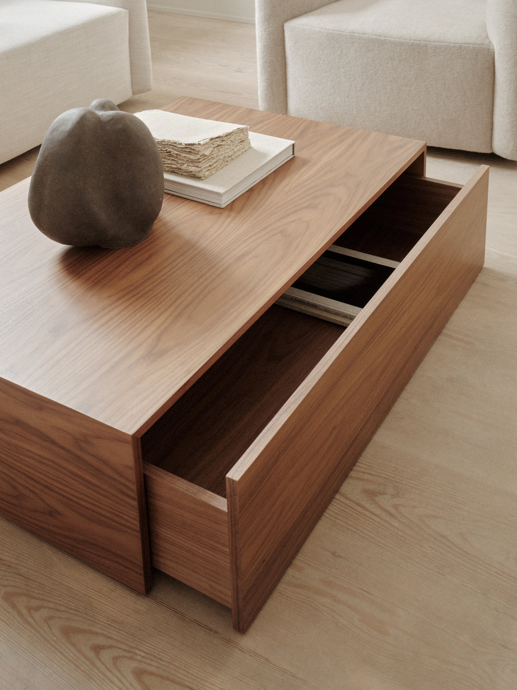 New Works Mass Coffee Table w. Drawer, a rectangular modern minimalist coffee table crafted from rich warm walnut wood with a visible grain and a sleek, low-profile design.