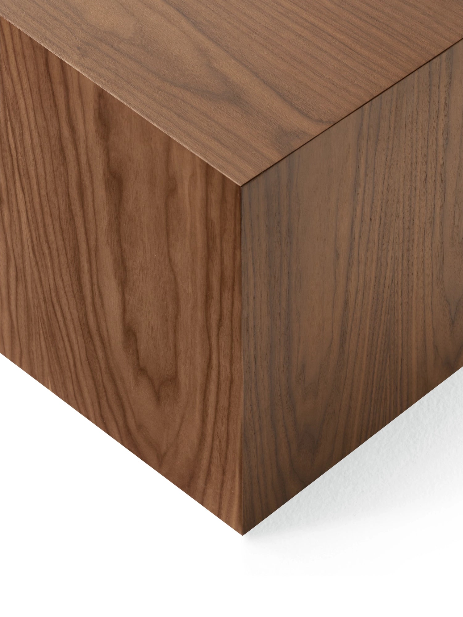 New Works Mass Side Table, a contemporary minimalist side table crafted from rich dark walnut wood, featuring a substantial solid block silhouette with clean, sharp edges and a visible natural wood grain. This sculptural dark wood accent table is perfect for modern living rooms, industrial chic interiors, or as a sophisticated bedside table.