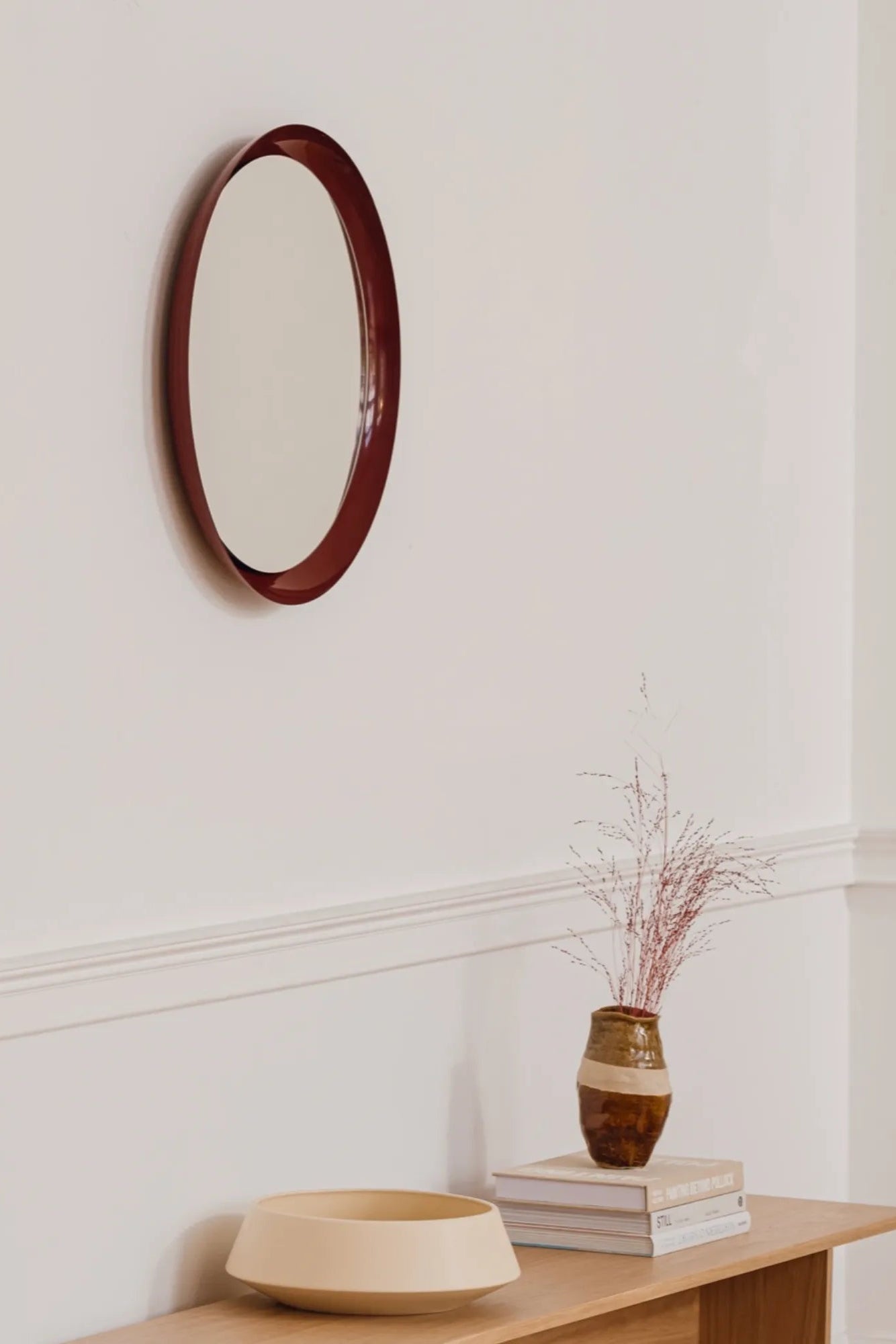 Allo Mirror positioned against white wall, adding depth to the space