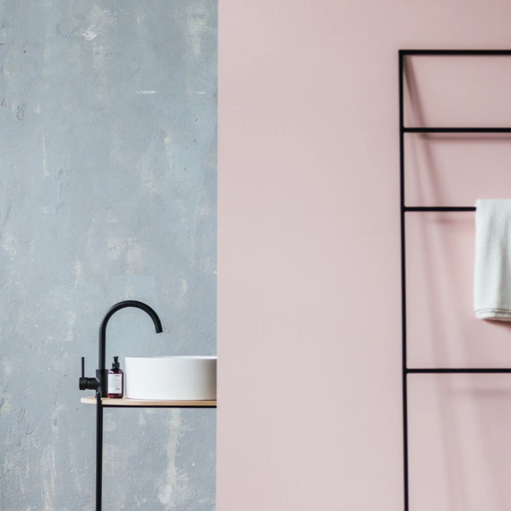 noo.ma Tows Ladder, a modern minimalist freestanding towel ladder crafted from matte black metal with a sleek, industrial design, featuring multiple rungs for towels and an integrated natural wood shelf.