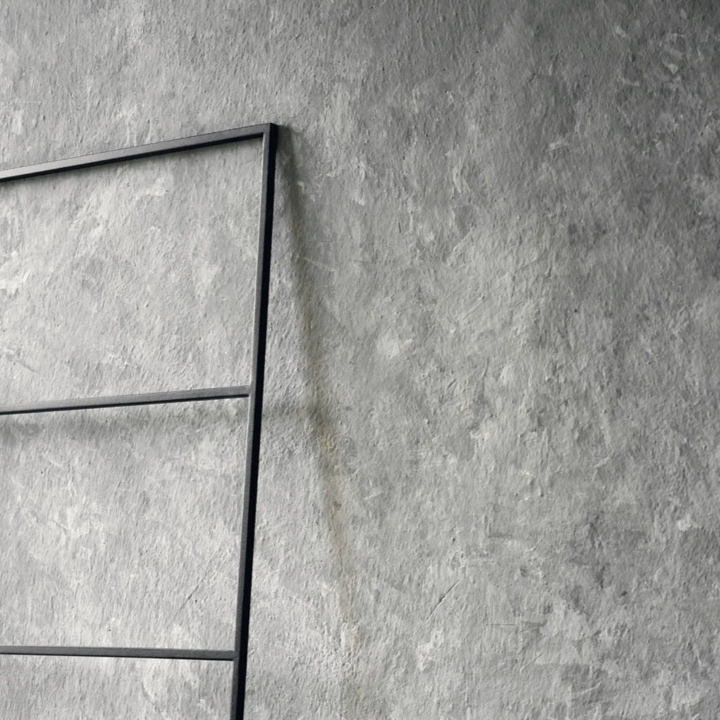 noo.ma Tows Ladder, a sleek modern minimalist towel ladder crafted from durable matte black metal, featuring a tall rectangular frame with multiple horizontal rungs for convenient towel storage. This freestanding black towel rack is perfect for contemporary bathroom accessories, industrial chic interiors, or Scandinavian-inspired spaces.