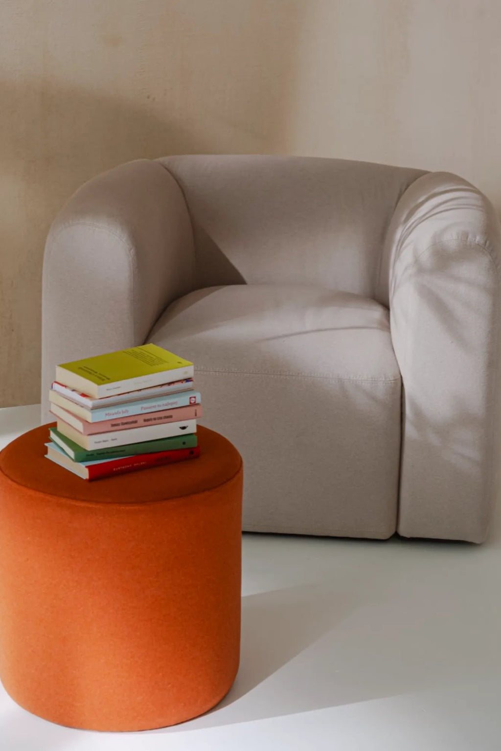 noo.ma Flom Armchair, a light beige upholstered lounge chair featuring a soft, textured bouclé-style fabric and a distinctive curved, organic modern silhouette.