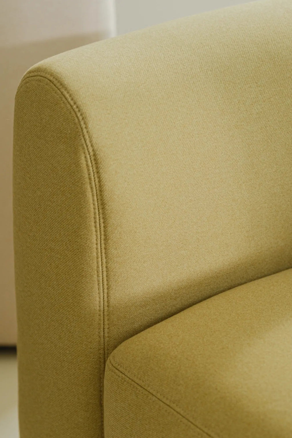 noo.ma Flom Armchair, a contemporary lounge chair upholstered in a rich chartreuse green woven fabric with a soft, textured finish and elegant piping detail along its seams.