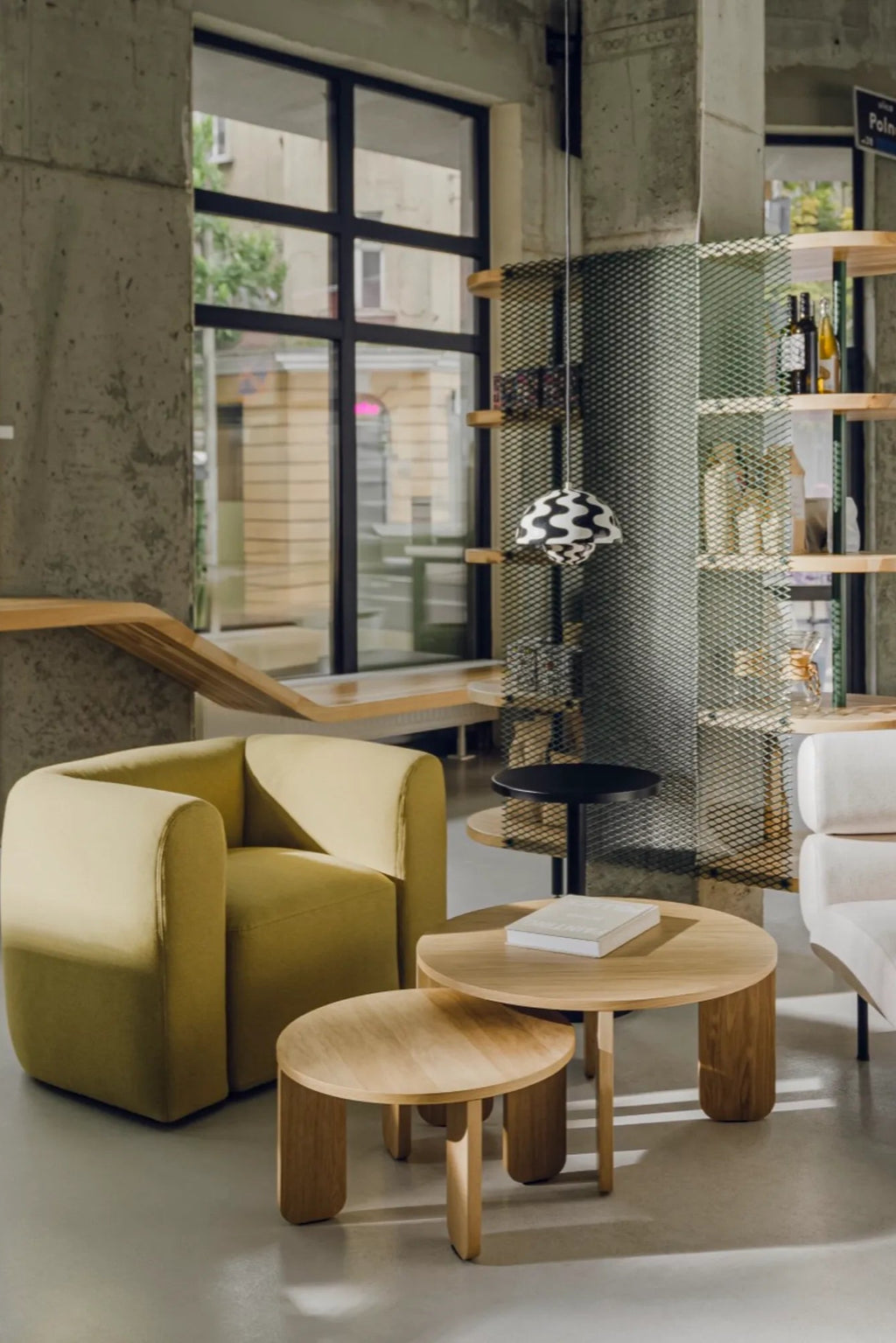 noo.ma Flom Armchair, a contemporary lounge chair upholstered in a muted chartreuse green fabric with a soft, rounded, sculptural silhouette and deep comfortable seating.