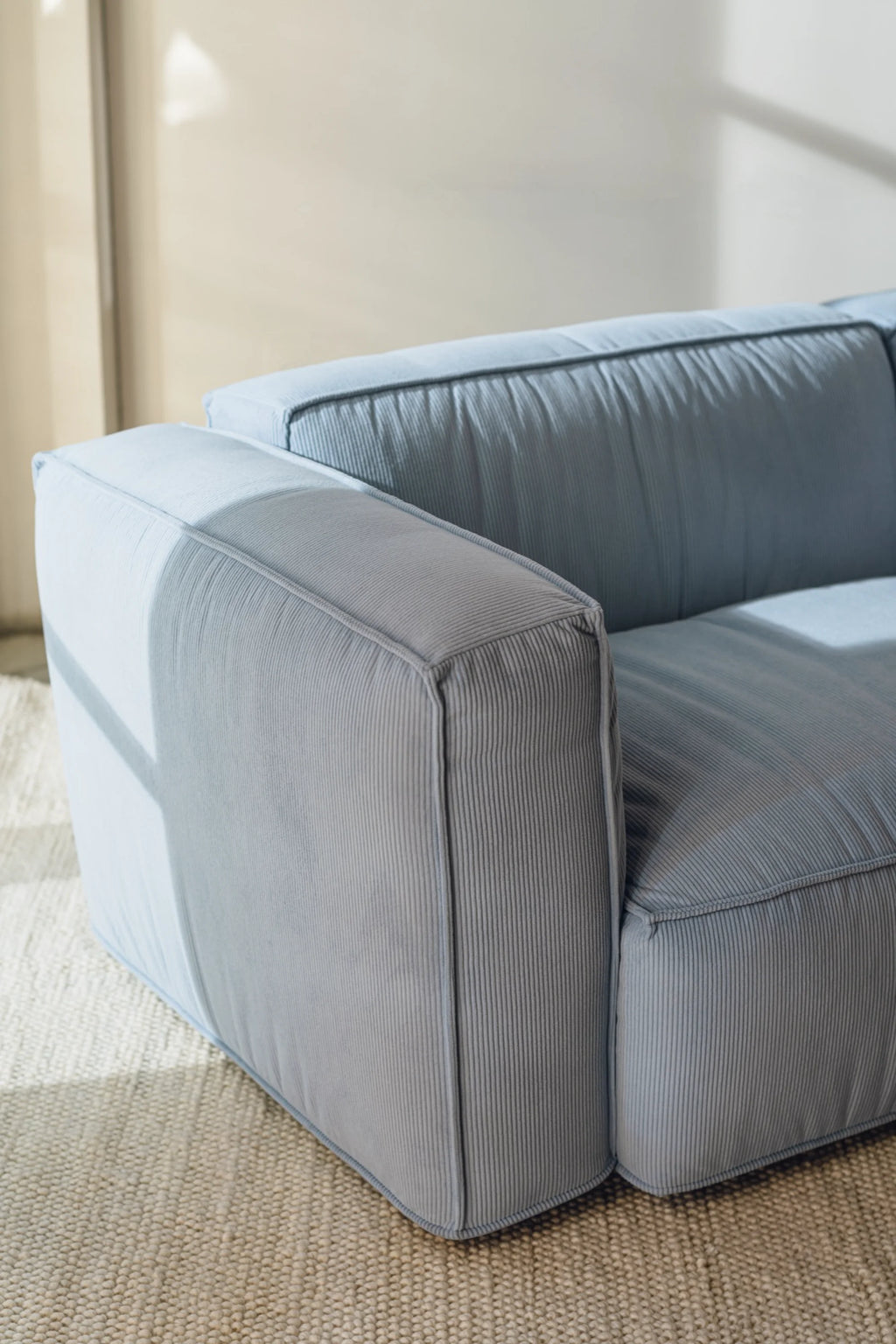 noo.ma Lobi Sofa 3-seater, a contemporary 3-seater sofa upholstered in plush light blue corduroy fabric with a distinctive ribbed texture. This modern minimalist sofa features clean lines, deep seating, and blocky armrests, perfect for a Scandinavian living room or a cozy contemporary lounge space.
