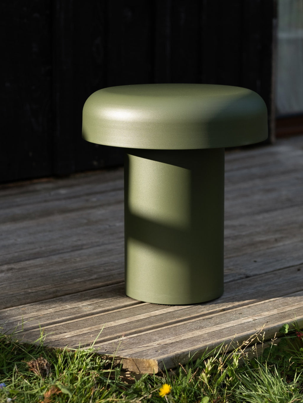 noo.ma Outdoor Miko Side Table, a modern minimalist olive green outdoor side table with a unique mushroom-inspired silhouette. This contemporary accent table features a sturdy cylindrical base and a wide, rounded top, crafted from durable powder-coated metal with a matte finish. Ideal as stylish patio furniture or a garden table for modern outdoor living spaces and Scandinavian-inspired decks.