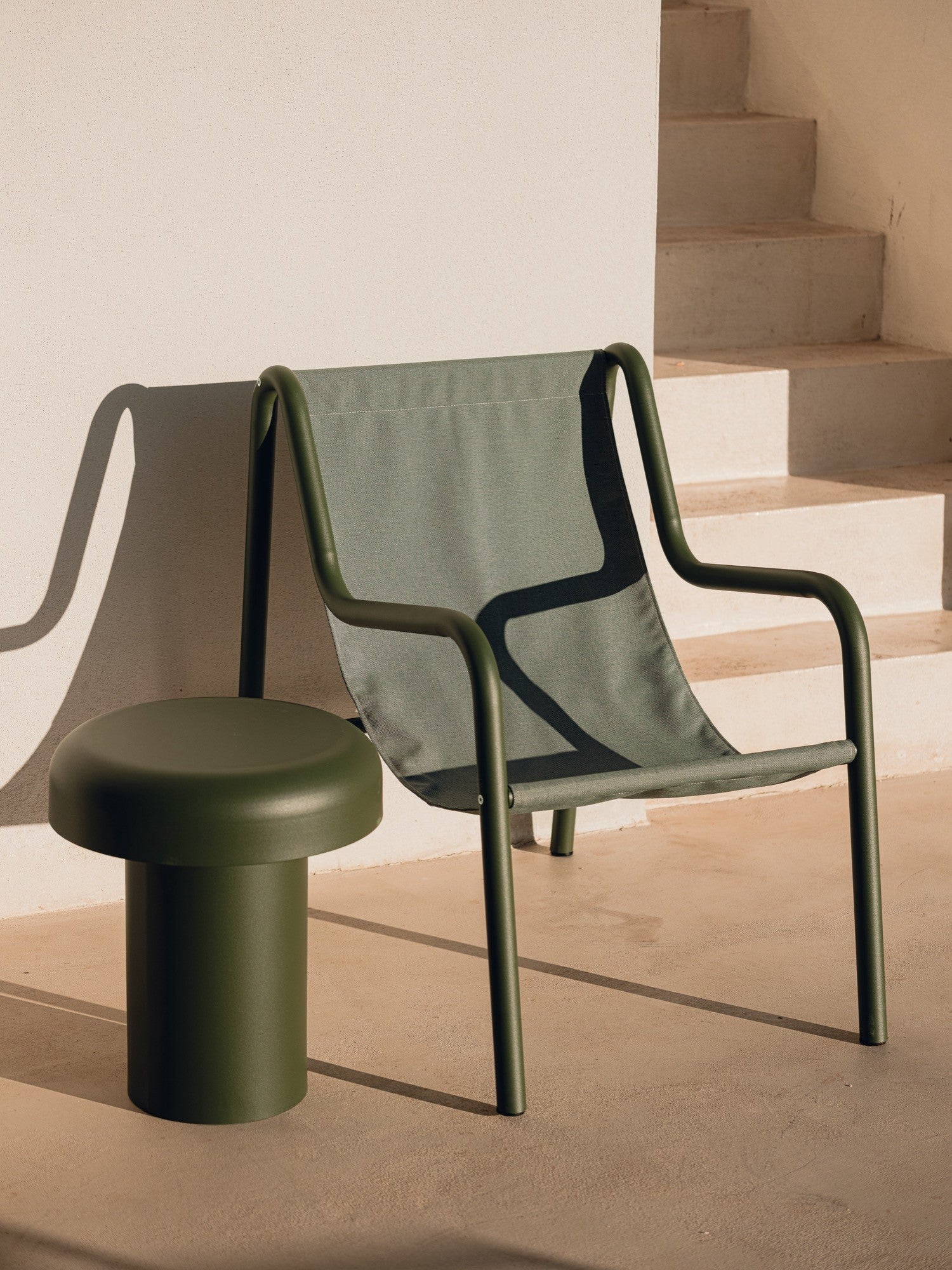 noo.ma Outdoor Miko Side Table, a dark green matte metal outdoor side table with a sculptural, modern minimalist design, featuring a sturdy cylindrical base and a smoothly rounded, mushroom-shaped top. Crafted from durable powder-coated steel, this contemporary accent table is ideal for adding a touch of sophisticated color to outdoor living spaces, patios, or garden areas.
