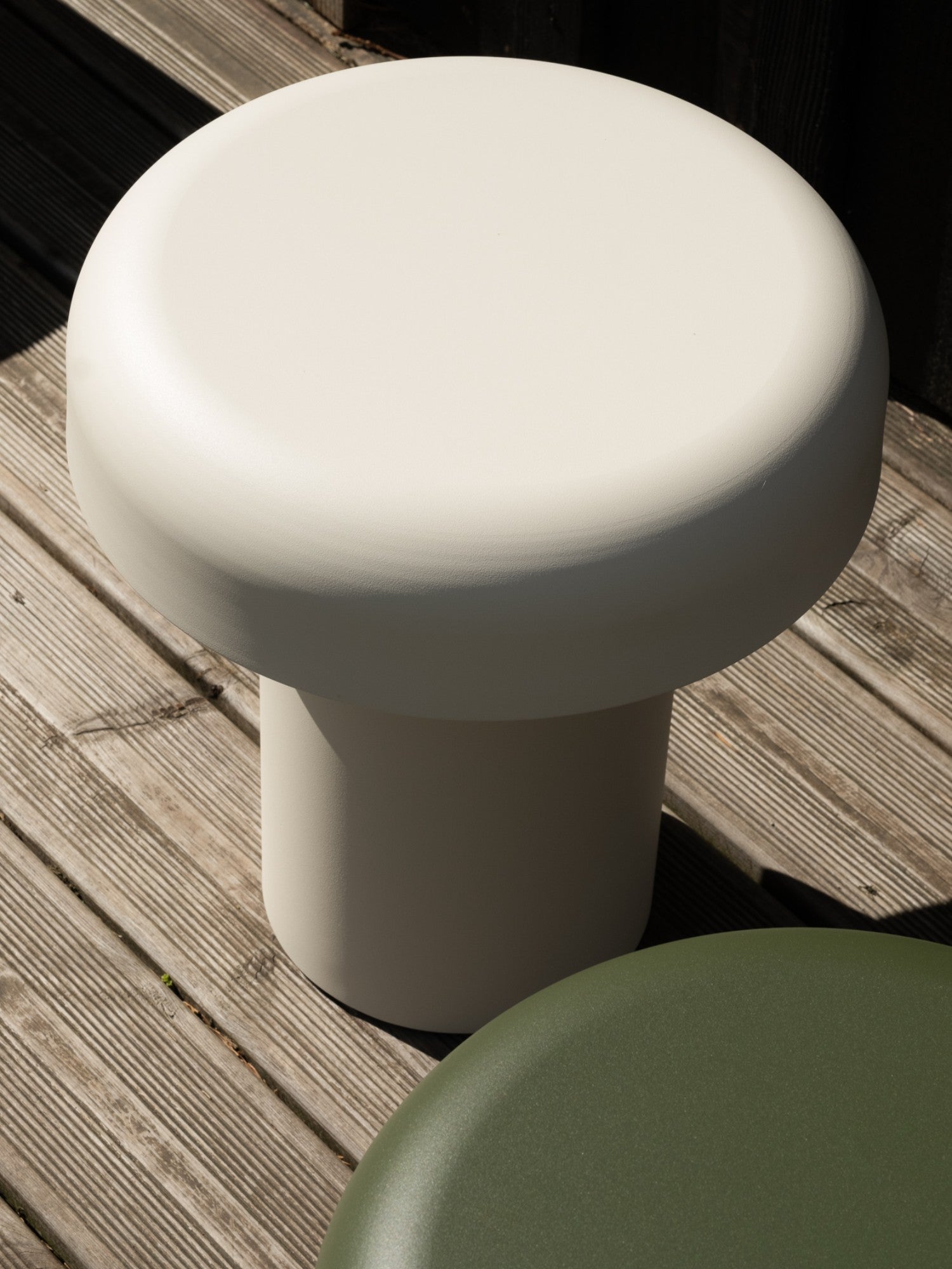 noo.ma Outdoor Miko Side Table, a modern minimalist patio table in a soft cream-greige finish, distinguished by its sculptural mushroom-like shape with a robust cylindrical base and a wide,.