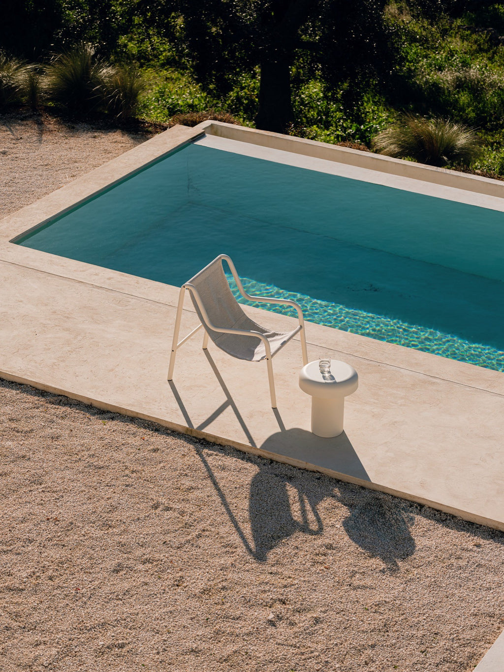noo.ma Outdoor Miko Side Table, a modern minimalist outdoor accent table in a creamy off-white color with a smooth matte finish and a distinctive sculptural, mushroom-like silhouette. This round outdoor side table is perfect for poolside lounging, contemporary patio settings, or as a stylish garden table for organic modern outdoor spaces.