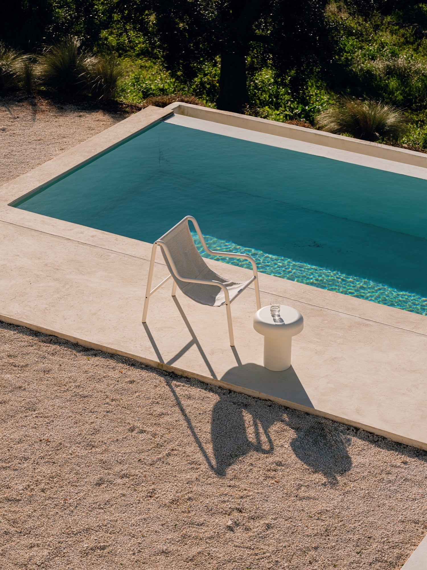 noo.ma Outdoor Miko Side Table, a modern minimalist outdoor accent table in a creamy off-white color with a smooth matte finish and a distinctive sculptural, mushroom-like silhouette. This round outdoor side table is perfect for poolside lounging, contemporary patio settings, or as a stylish garden table for organic modern outdoor spaces.