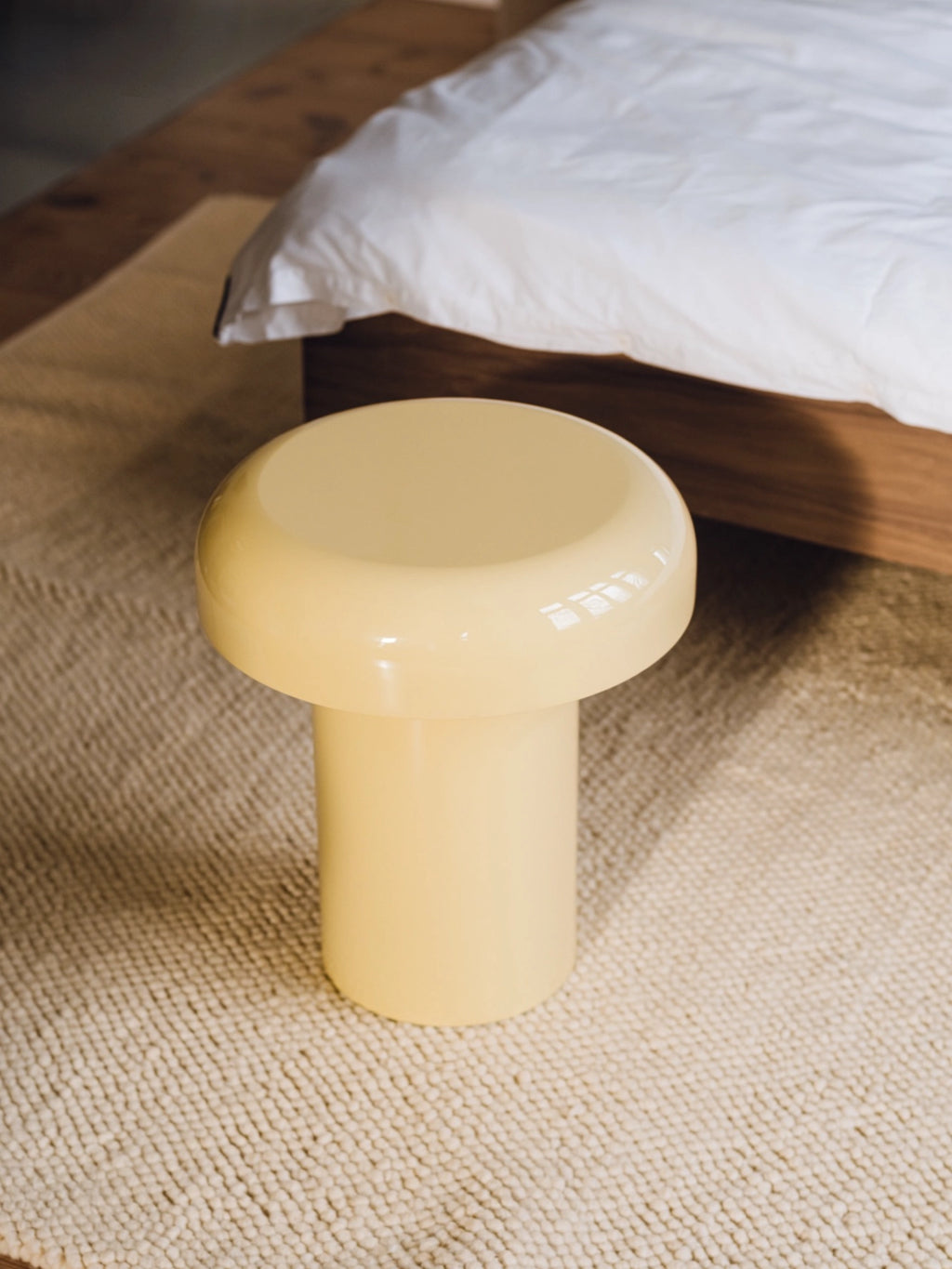 noo.ma Miko Side Table, a creamy yellow mushroom-shaped accent table featuring a smooth, glossy lacquered finish with a distinctive rounded top and sturdy cylindrical base. This retro-inspired, mid-century modern side table offers a playful yet minimalist aesthetic. Perfect as a bedside table, living room accent, or contemporary nightstand for modern and organic interiors.