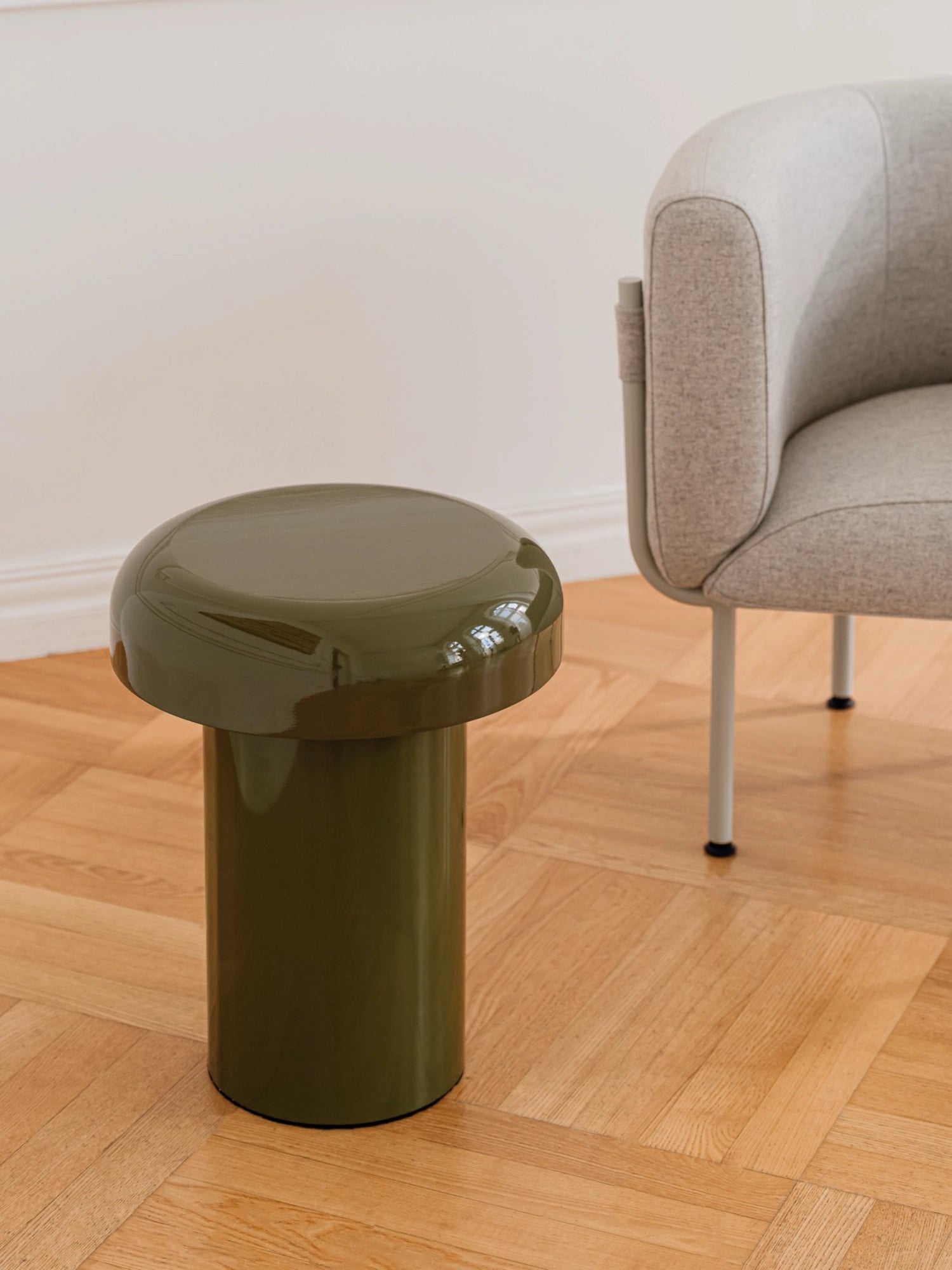 noo.ma Miko Side Table, a contemporary olive green side table with a high-gloss lacquered finish, featuring a distinctive mushroom-like silhouette with a wide round top and a sturdy cylindrical base. This minimalist yet playful accent table is perfect for adding a pop of color to modern living rooms, bedrooms, or as a stylish statement piece.