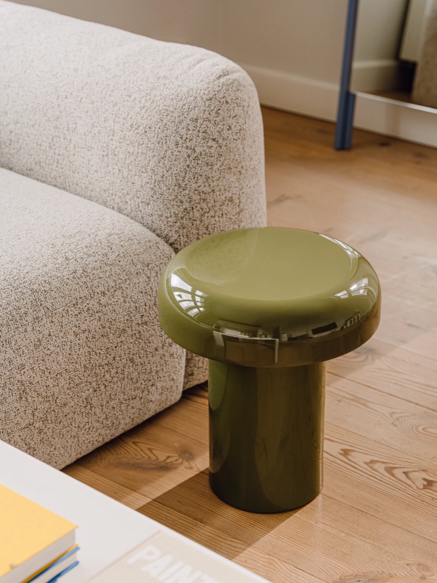 noo.ma Miko Side Table, a contemporary olive green accent table with a sleek, glossy lacquered finish and a distinctive mushroom-like sculptural shape. This modern minimalist side table features a sturdy cylindrical base and a wider, rounded top, offering a playful yet sophisticated design.