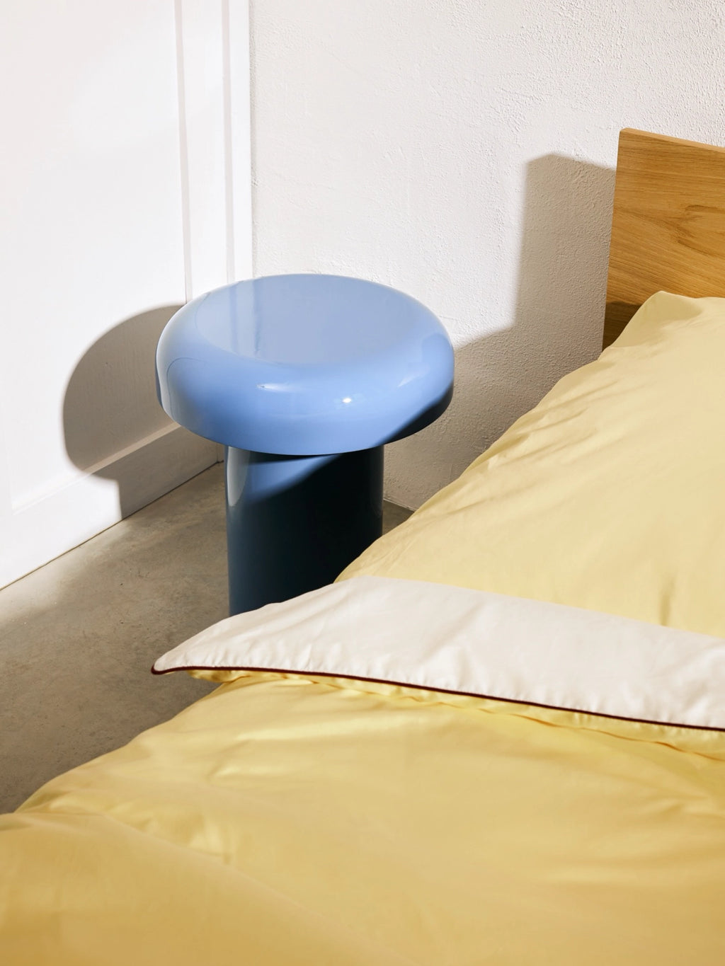 noo.ma Miko Side Table, a contemporary accent table featuring a glossy two-tone lacquer finish with a vibrant periwinkle blue mushroom-like rounded top and a darker blue cylindrical base. Its sculptural, modern minimalist design makes it a playful yet sophisticated bedside table or living room accent for small spaces.