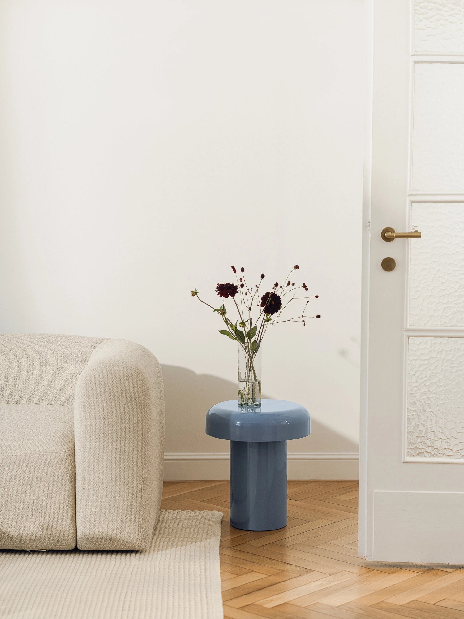 noo.ma Miko Side Table, a modern sculptural accent table featuring a smooth glossy dusty blue lacquer finish with a distinctive cylindrical base and wide mushroom-shaped top. This contemporary side table is perfect for minimalist living rooms or as a stylish bedside table in organic modern bedrooms.