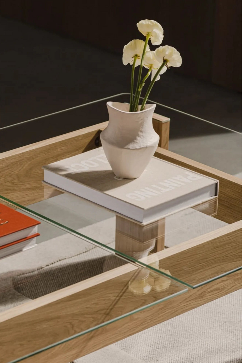 noo.ma Naiko Coffee Table, a modern minimalist coffee table featuring a light natural oak wood frame and multiple clear glass shelves, creating an open, airy silhouette. Its clean lines and mixed material design make it a versatile piece for contemporary or Scandinavian living rooms. The multi-tier structure offers ample space for display and storage, ideal for modern homes.