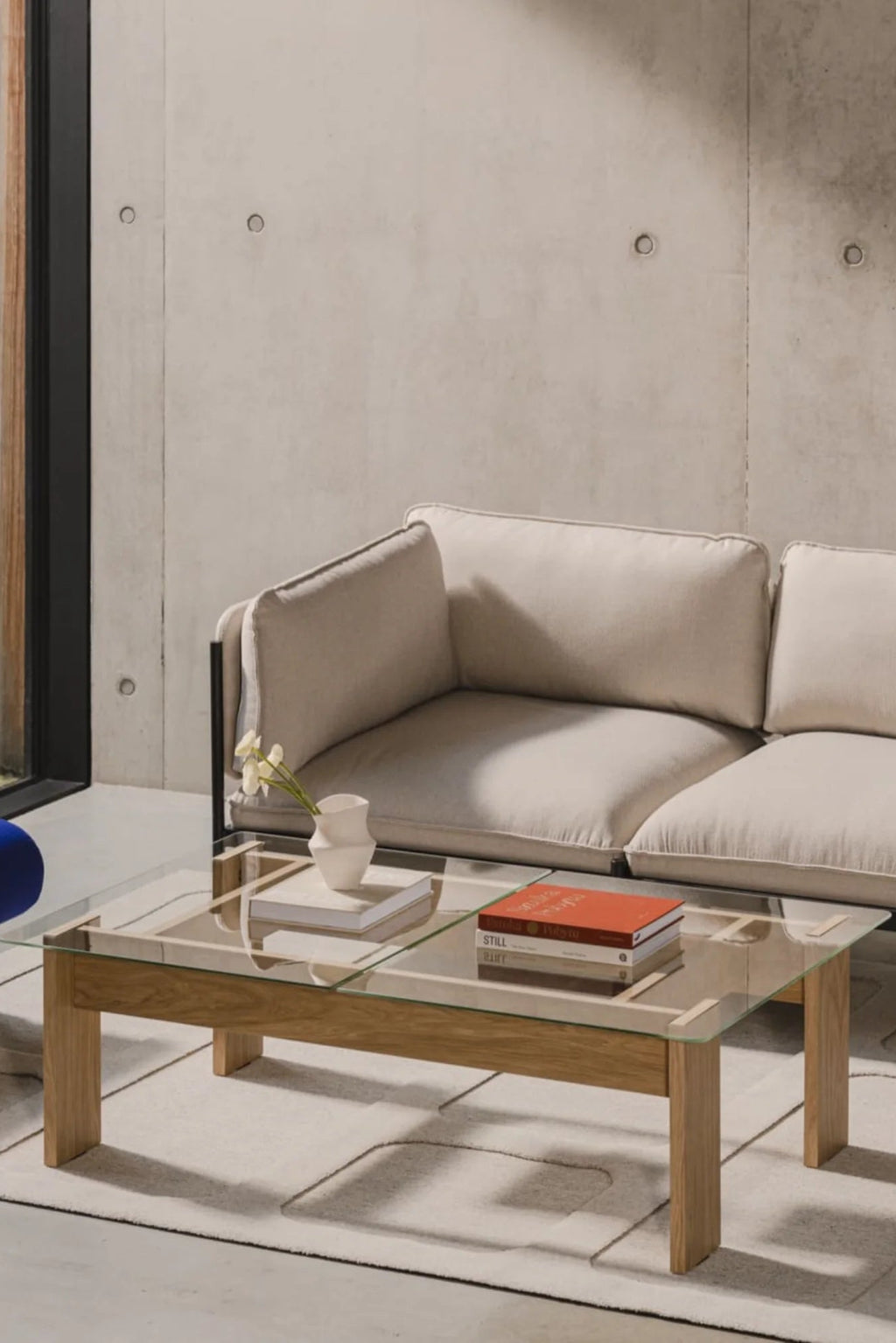 noo.ma Naiko Coffee Table, a modern minimalist rectangular coffee table featuring a clear glass tabletop. It is supported by a warm light natural solid oak wood frame with clean lines and sturdy rectangular legs. Ideal for contemporary living rooms, Scandinavian interiors, or Japandi-inspired spaces seeking a light and airy aesthetic.
