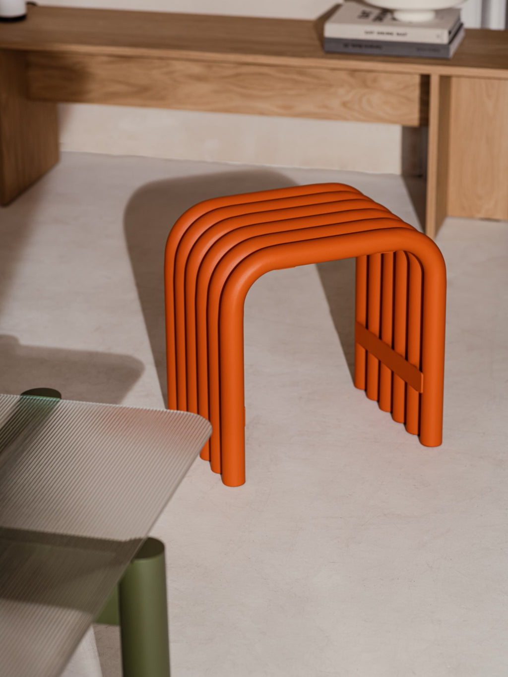 noo.ma Nokk Stool, a distinctive burnt orange tubular metal stool showcasing a modern minimalist design with parallel U-shaped tubes and a smooth matte powder-coated finish.