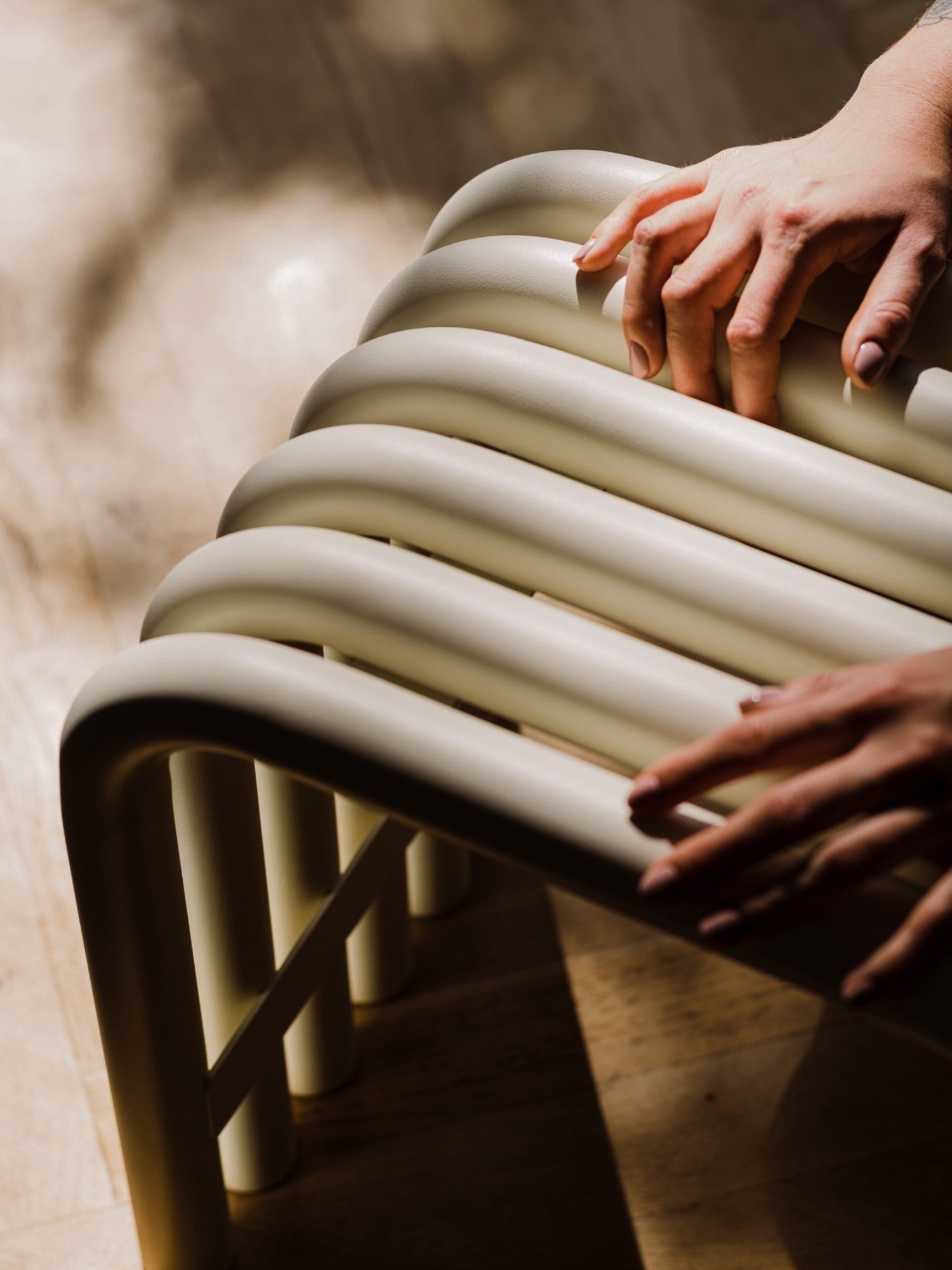 noo.ma Nokk Stool, a modern minimalist sculptural stool featuring a distinctive tubular design in a soft, pale sage green matte metal finish, creating a ribbed, organic silhouette. This contemporary accent stool is perfect for adding a touch of unique design to living rooms, entryways, or as a stylish bedroom bench.