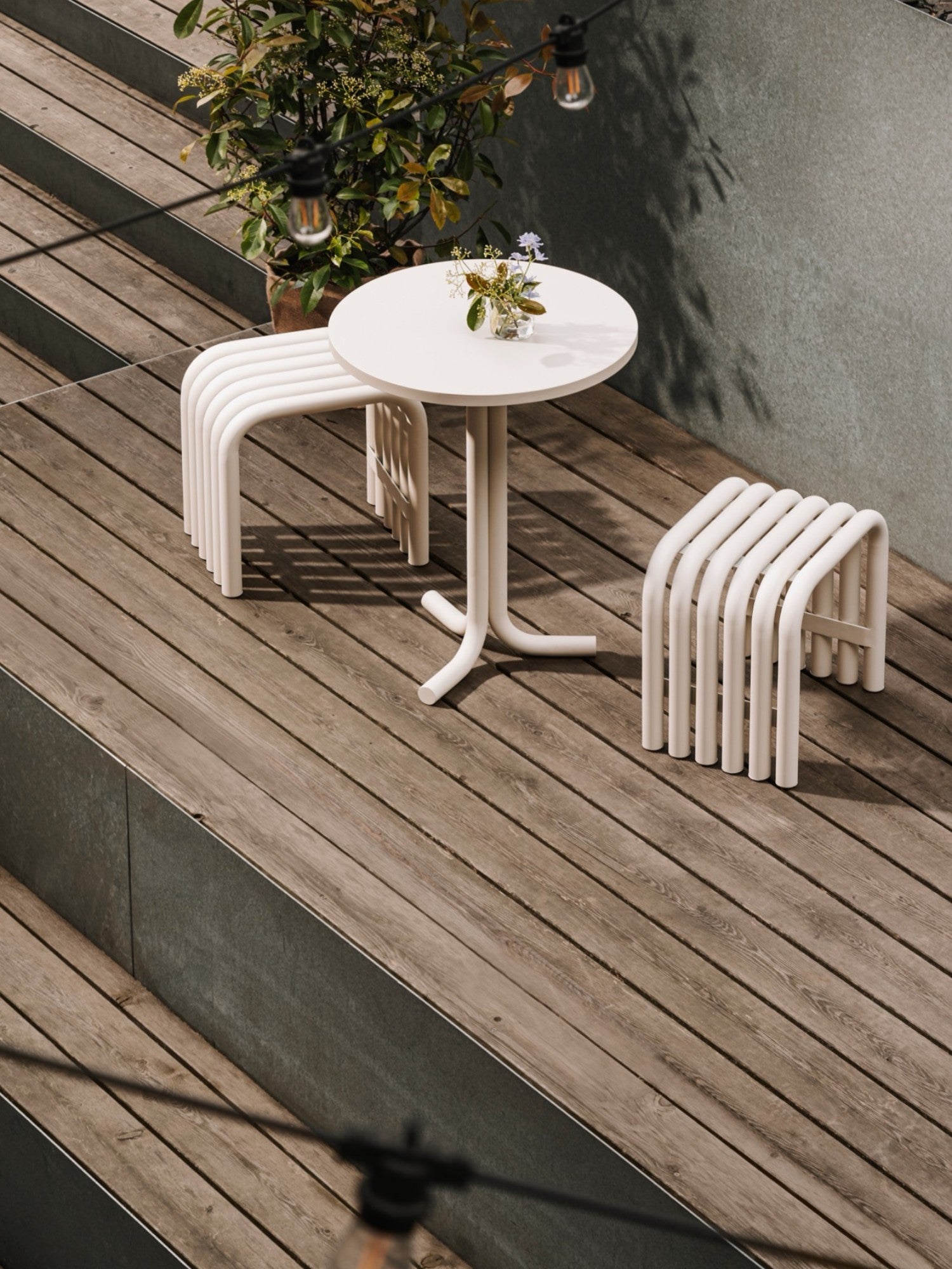 noo.ma Nokk Stool, an off-white modern minimalist outdoor stool crafted from durable powder-coated tubular metal, featuring a sculptural design with multiple gracefully curved tubes forming a distinctive seat and base.