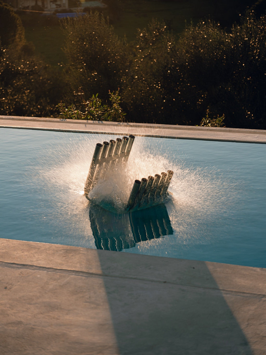 noo.ma Nokk Stool, a sculptural dark steel stool composed of multiple vertical cylindrical tubes arranged in an angular, Brutalist-inspired design with a matte black metal finish.