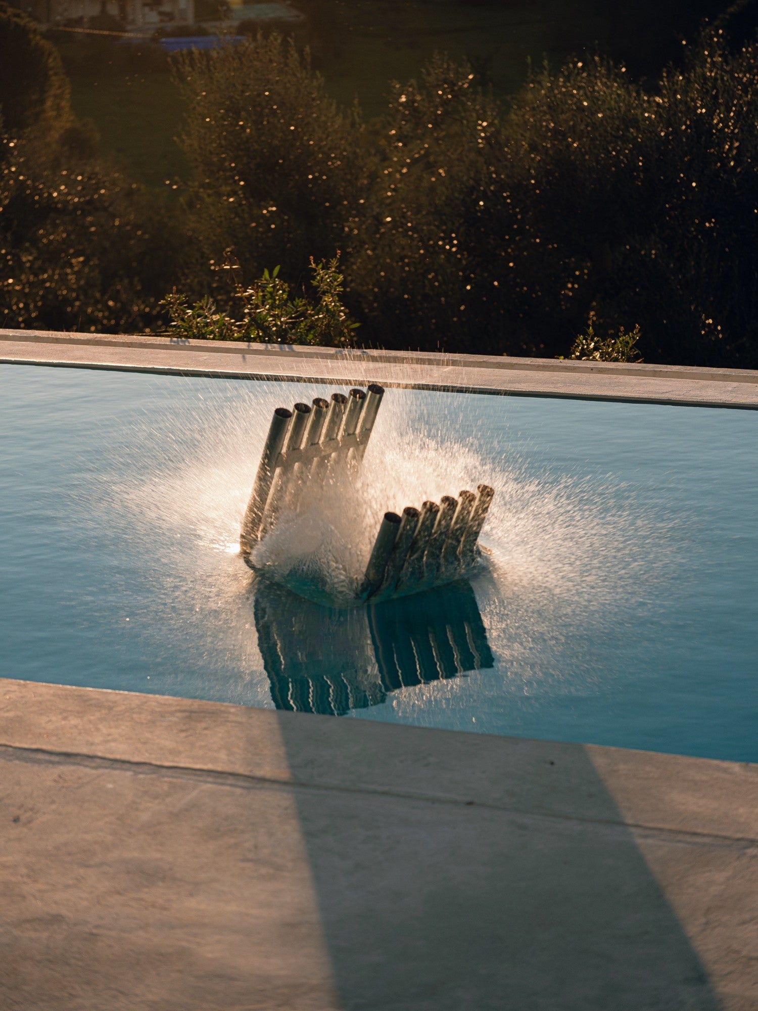 noo.ma Nokk Stool, a sculptural dark steel stool composed of multiple vertical cylindrical tubes arranged in an angular, Brutalist-inspired design with a matte black metal finish.