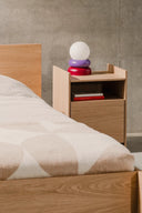 Otem Table Lamp casting a soft glow on a bedside table in a modern bedroom