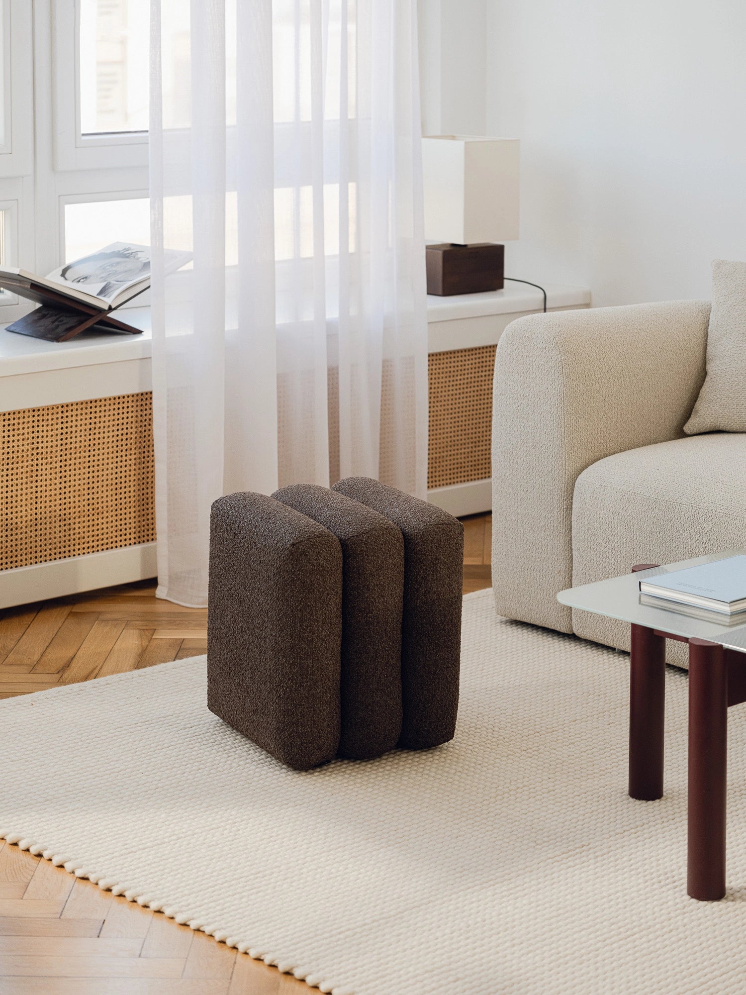 noo.ma Radd Pouf, a dark brown contemporary pouf upholstered in rich bouclé fabric, featuring a unique sculptural design with three plush, rounded vertical segments.