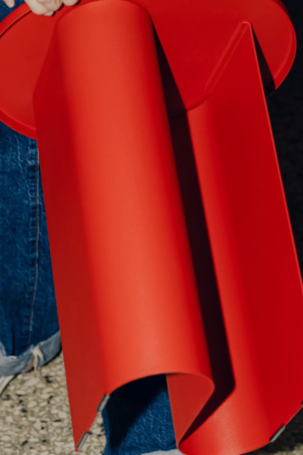 noo.ma Sato Side Table, a vibrant red modern minimalist side table featuring a smooth matte finish and a distinctive sculptural design with a cylindrical base and an elegantly flowing, curved side panel.