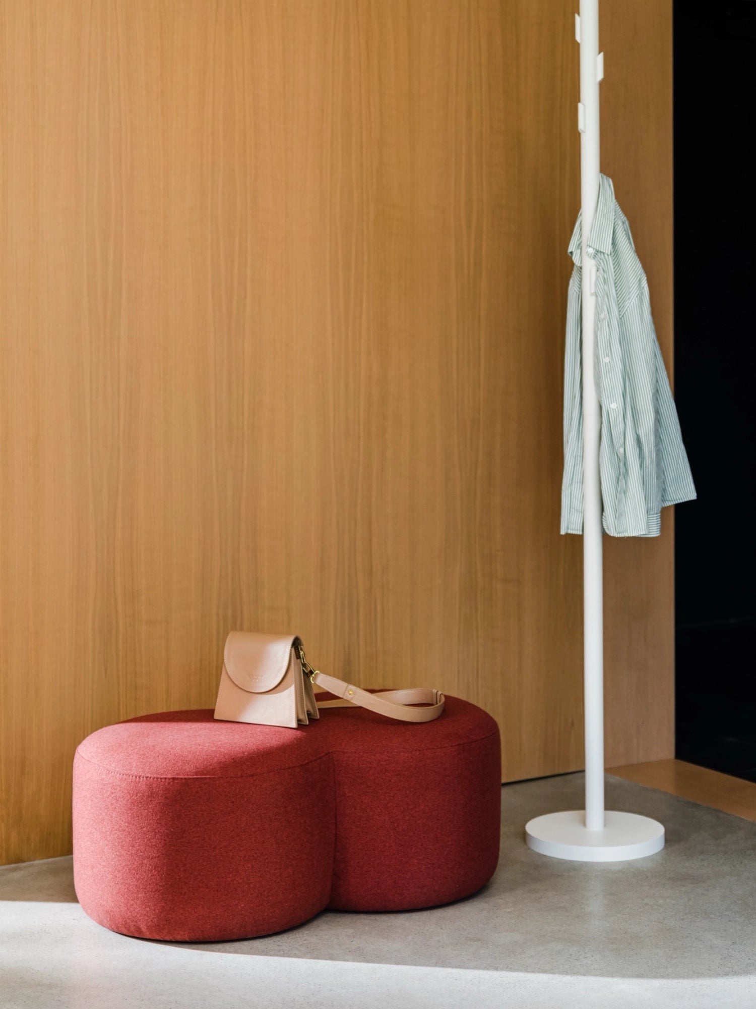 noo.ma Umbo Pouf, an organic modern deep red upholstered pouf featuring a distinctive rounded, peanut-shaped silhouette with soft, textured fabric. This versatile accent seating piece brings a warm pop of color and contemporary style to minimalist living rooms, Scandinavian bedrooms, or stylish entryways.