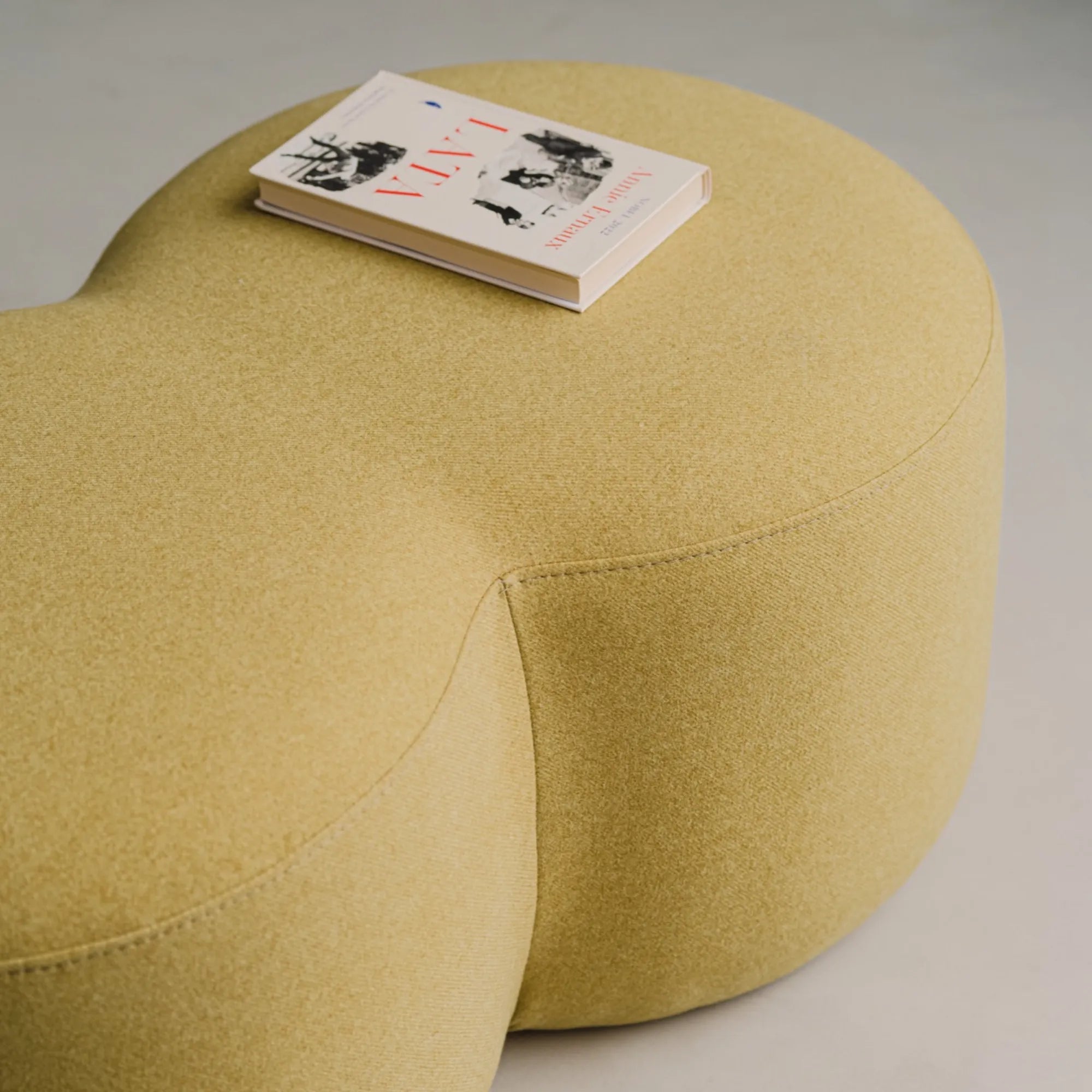 Circular white Umbo Pouf with knitted texture and soft cushion
