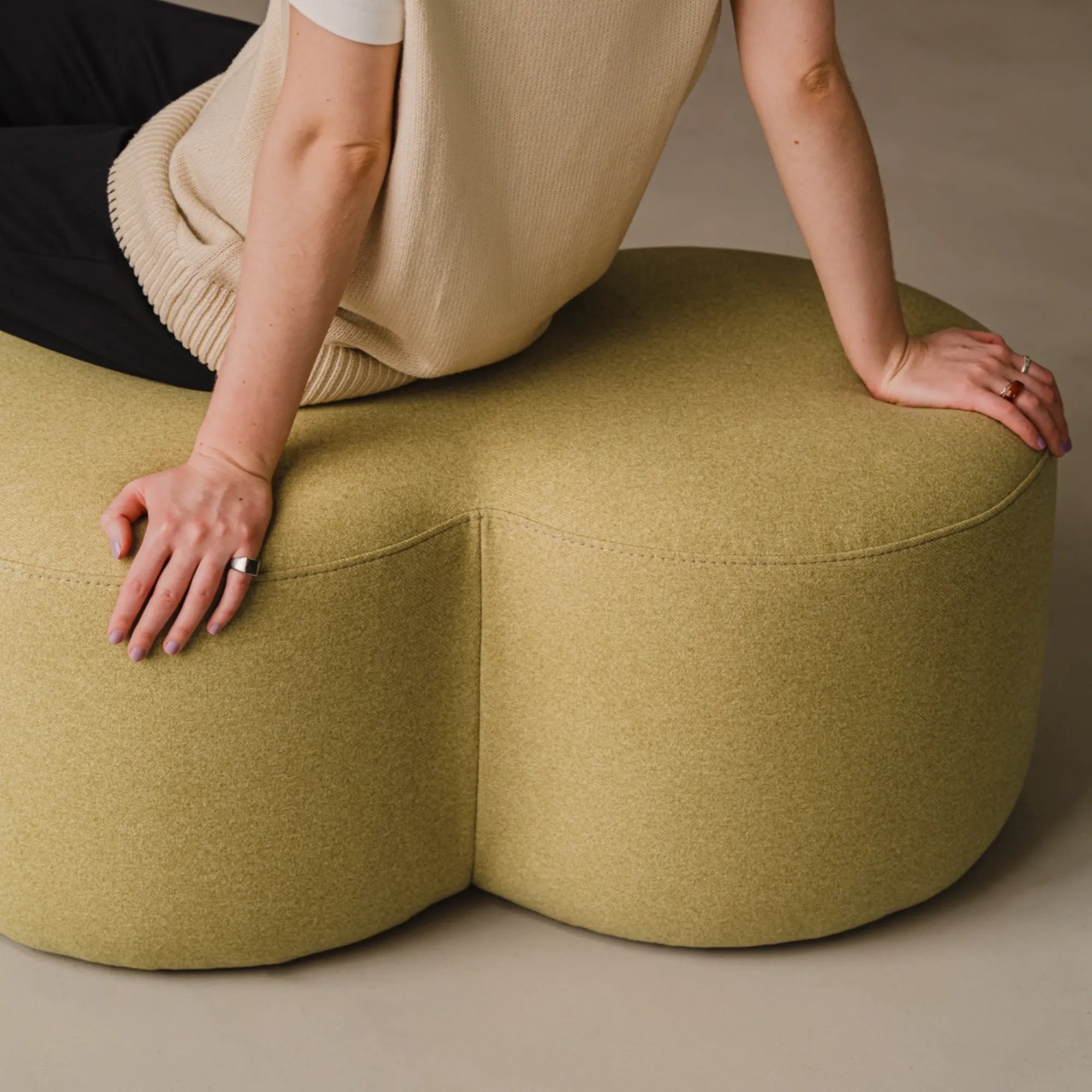 Oval green leather Umbo Pouf with stitching details and plush seat